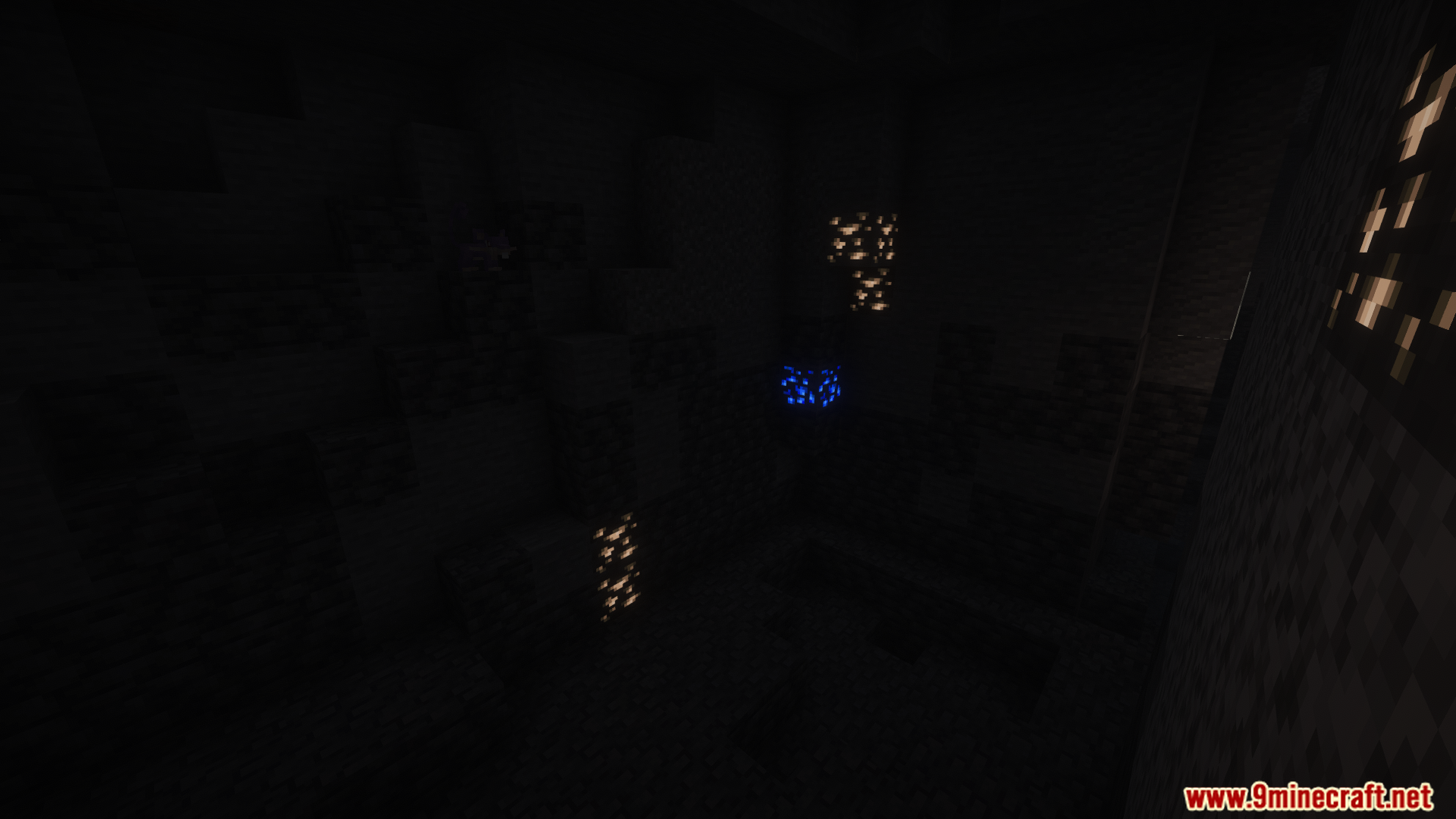 Glowing blue and gold ore veins in a pitch-black cave