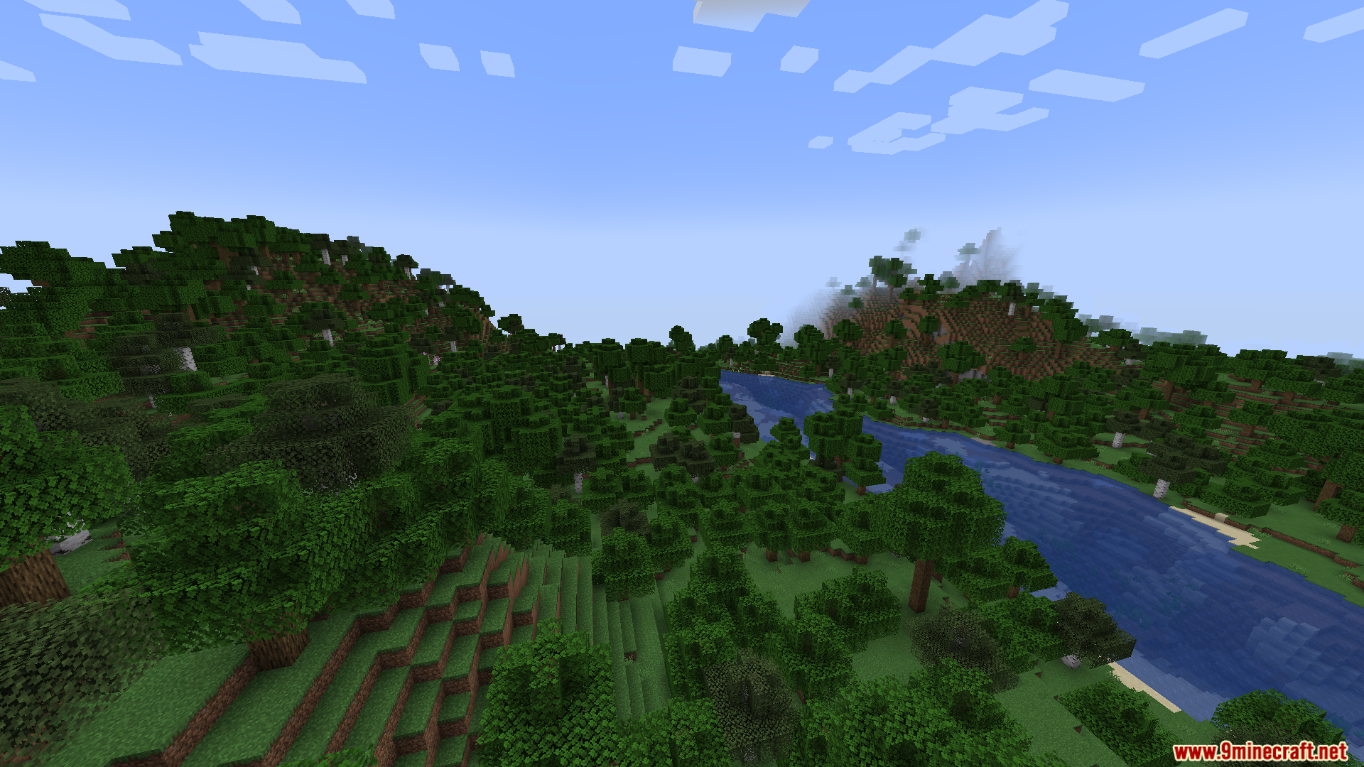 A wide river flowing through a hilly forest landscape