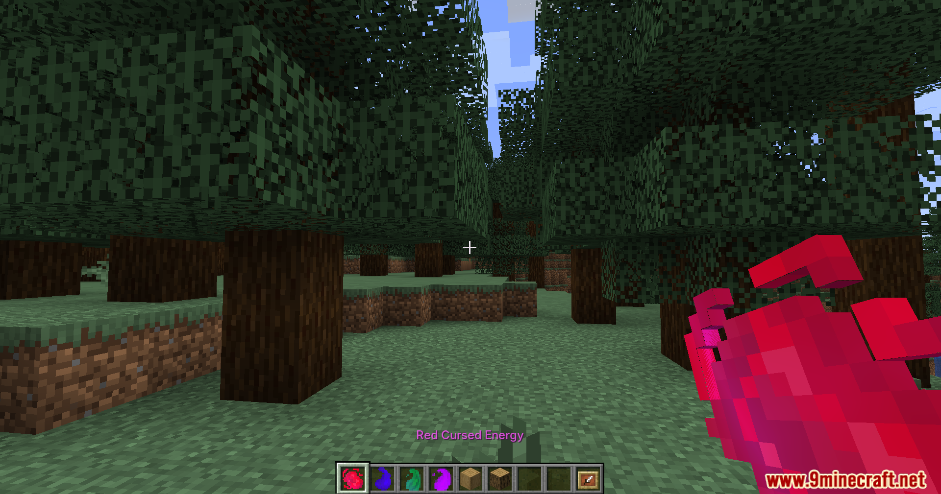 Player holding a red cursed energy item in a forest