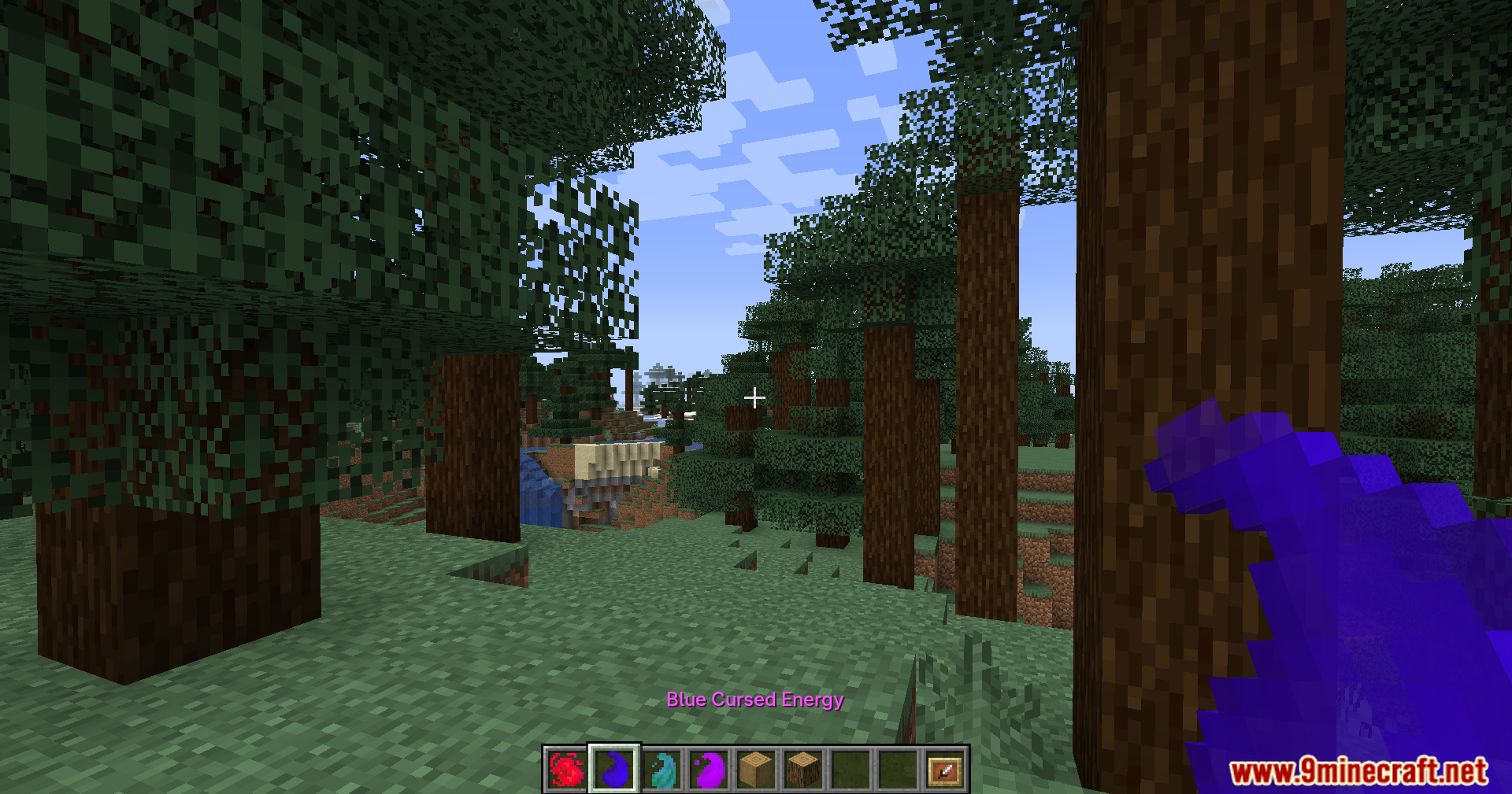 Player holding blue cursed energy item in a forest