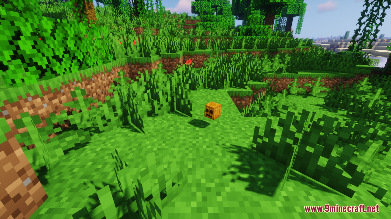 A cute smiling carved pumpkin block sitting on the grass in the world