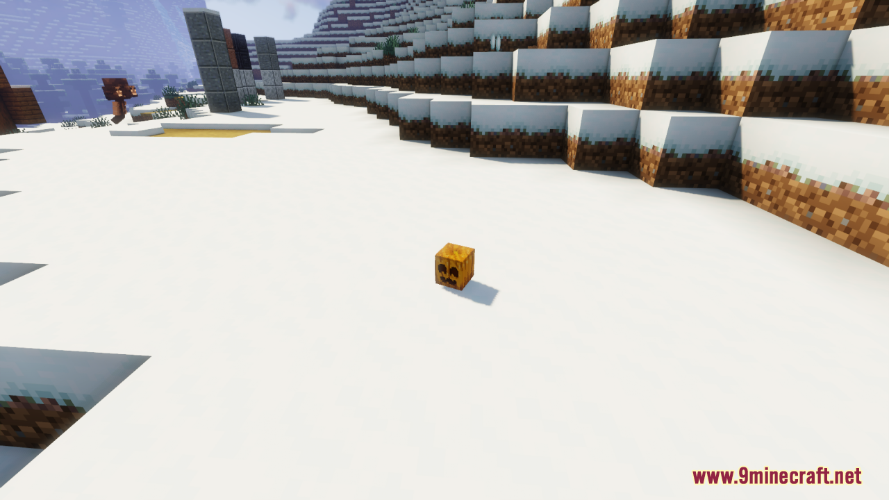 A carved pumpkin block with a cute smiling face on snowy ground
