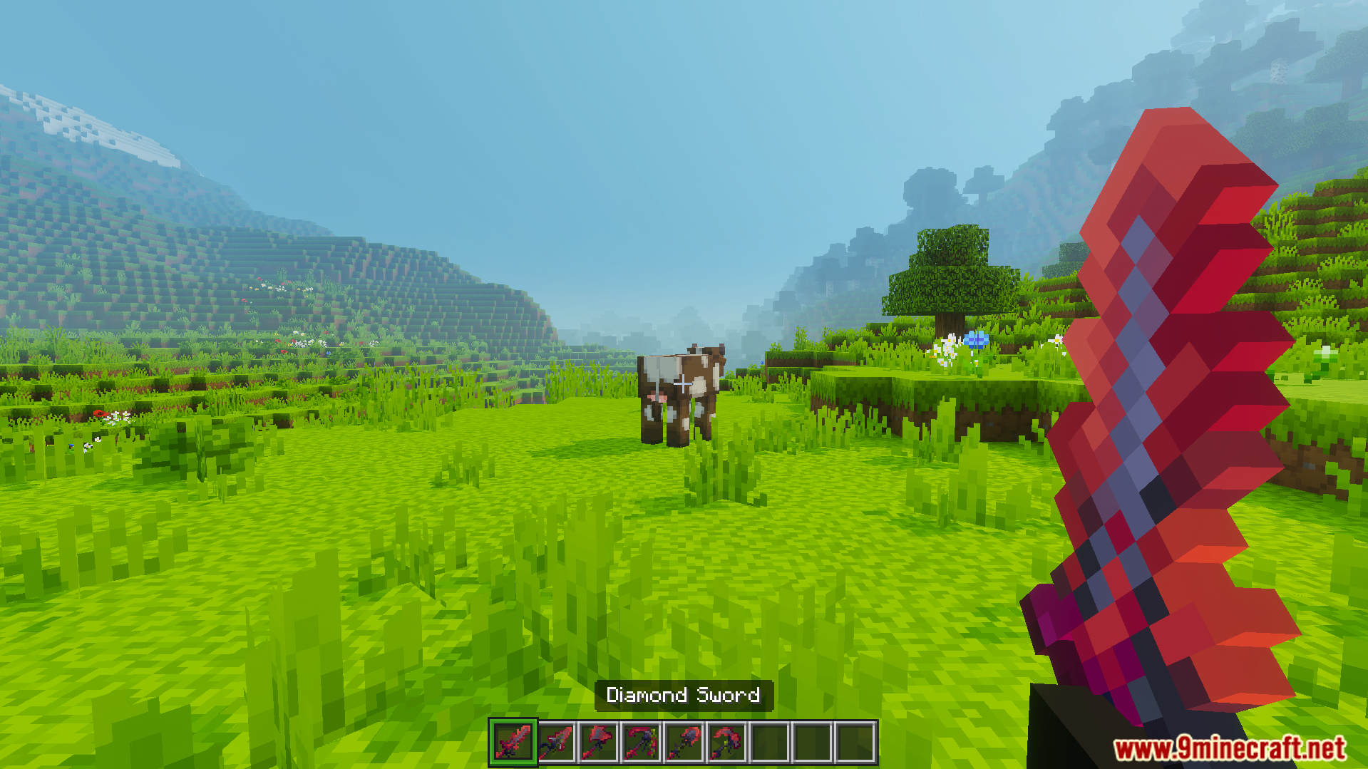 A player holds a red diamond sword in a grassy field