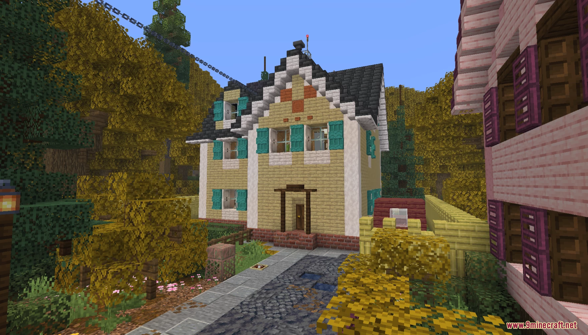Yellow suburban house with teal shutters in autumn