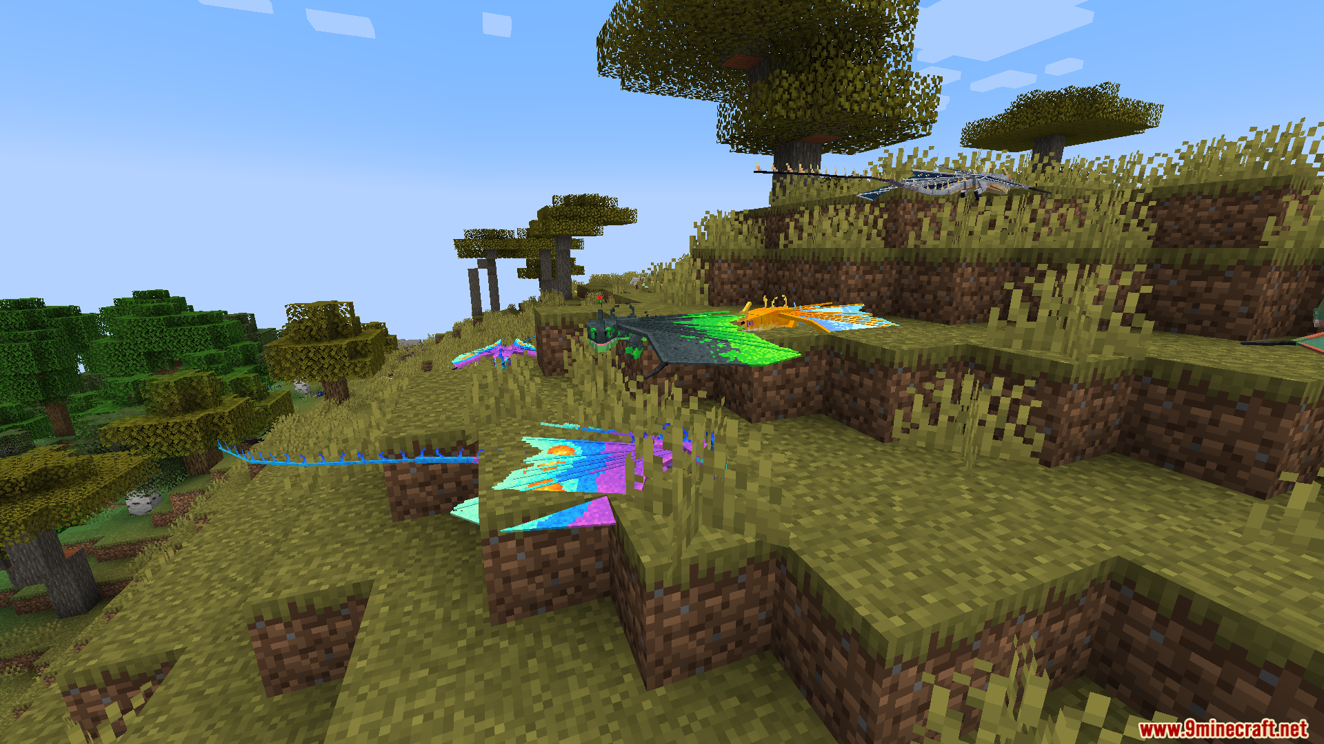 Brightly colored custom dragon variants hovering over a grassy hill landscape