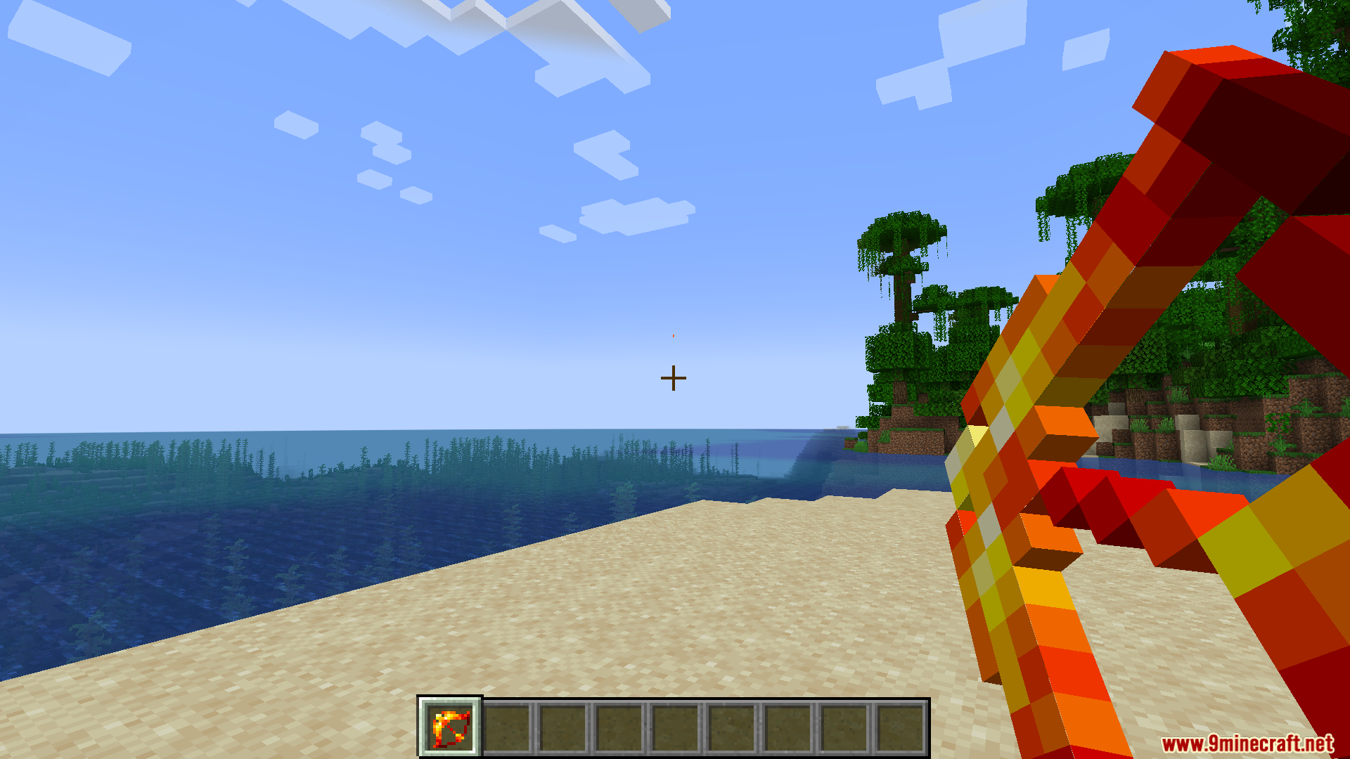 Player holding a fiery red wand on a sandy beach
