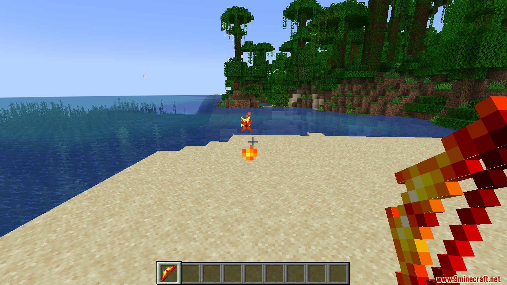 Player casting a fire spell from a wand on a beach