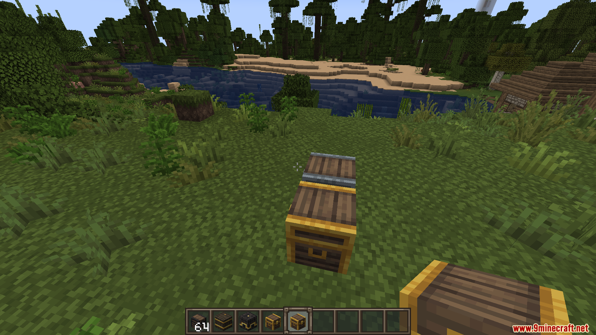 A medieval style wooden barrel placed on the grass near a river