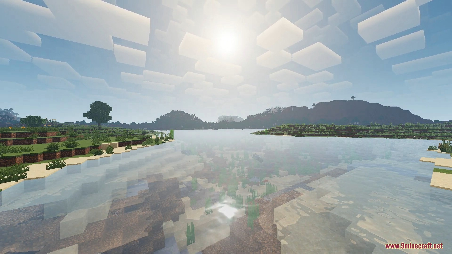 FirmamentCraft 5.0 Shader Screenshot 12 Sunny Minecraft landscape showing clear water reflections and blocky clouds in the sky