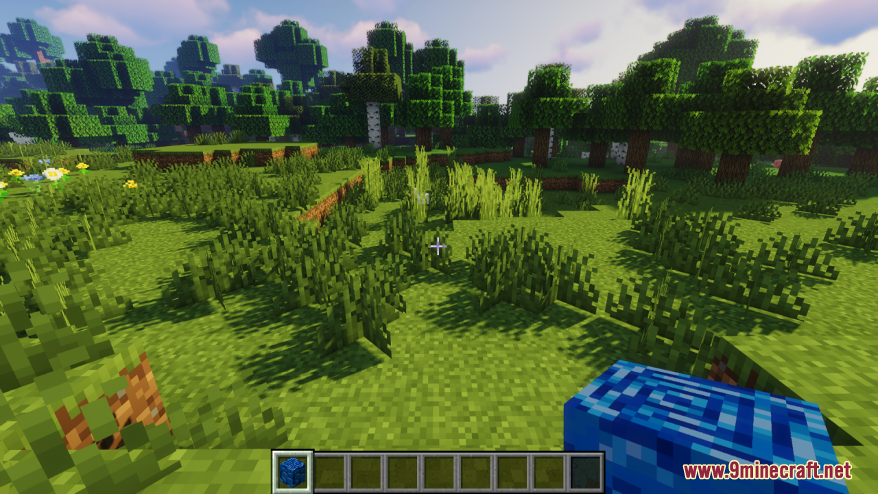 Player holding a blue block in a lush green forest