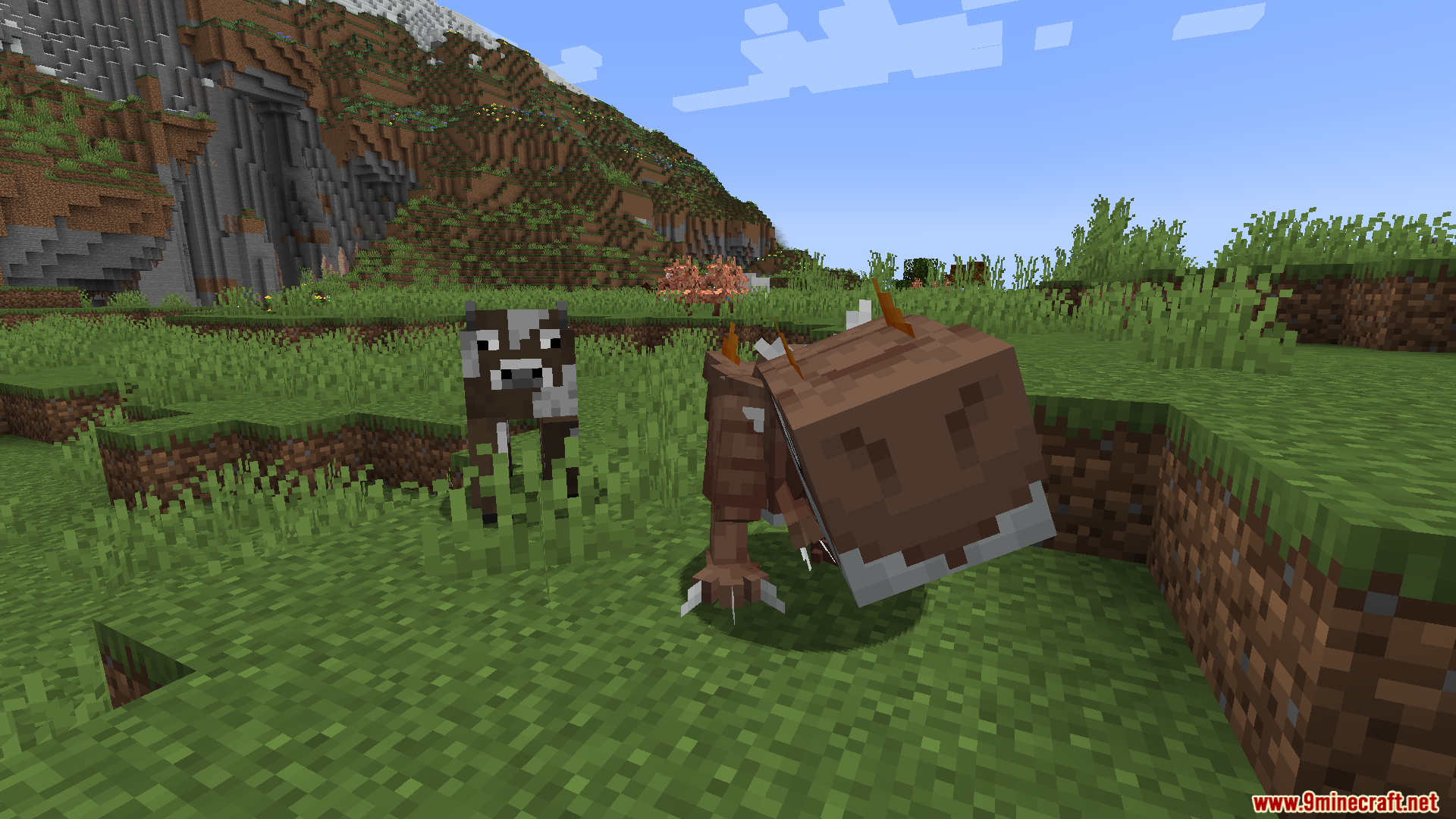 A Cobblemon Tauros stands near a regular cow