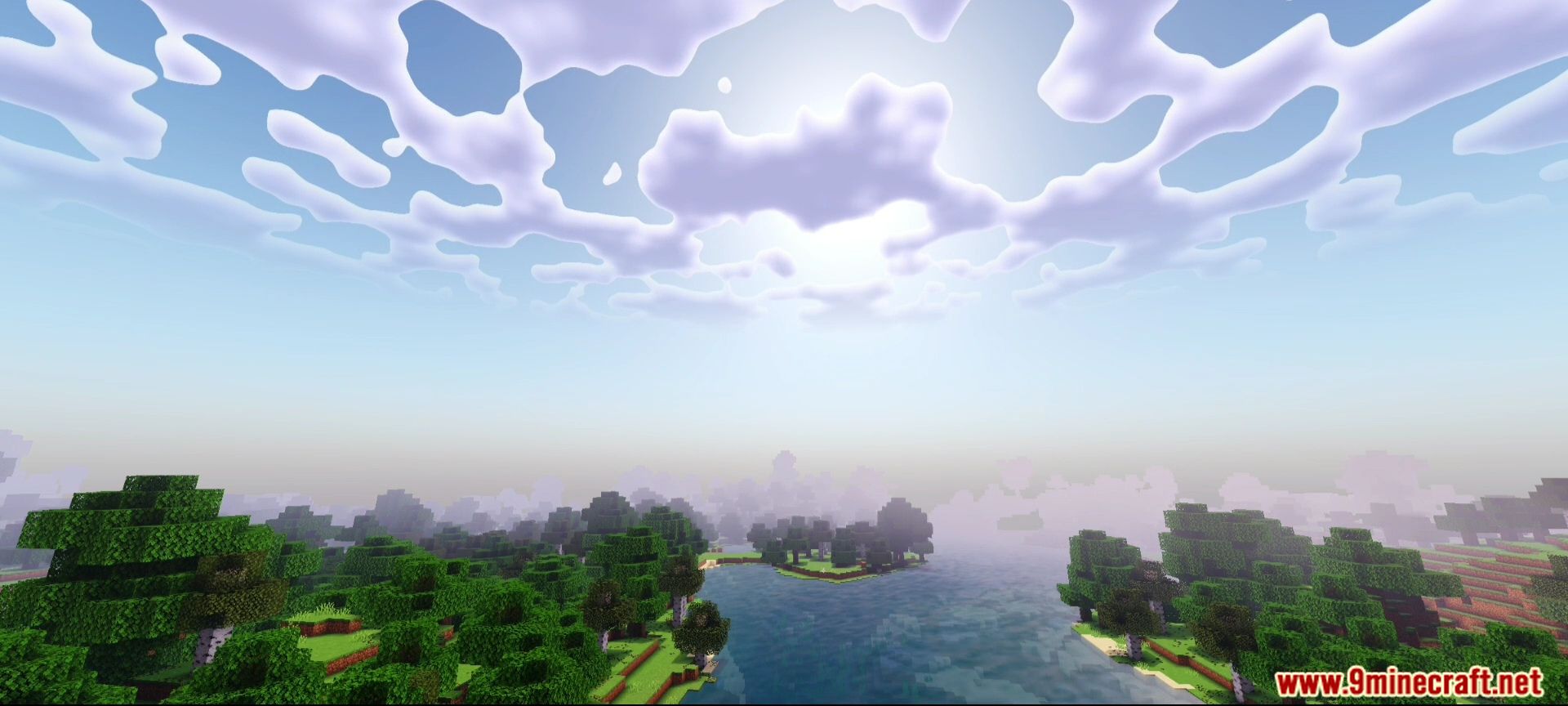 A scenic view of a river and forest under a cloudy sky