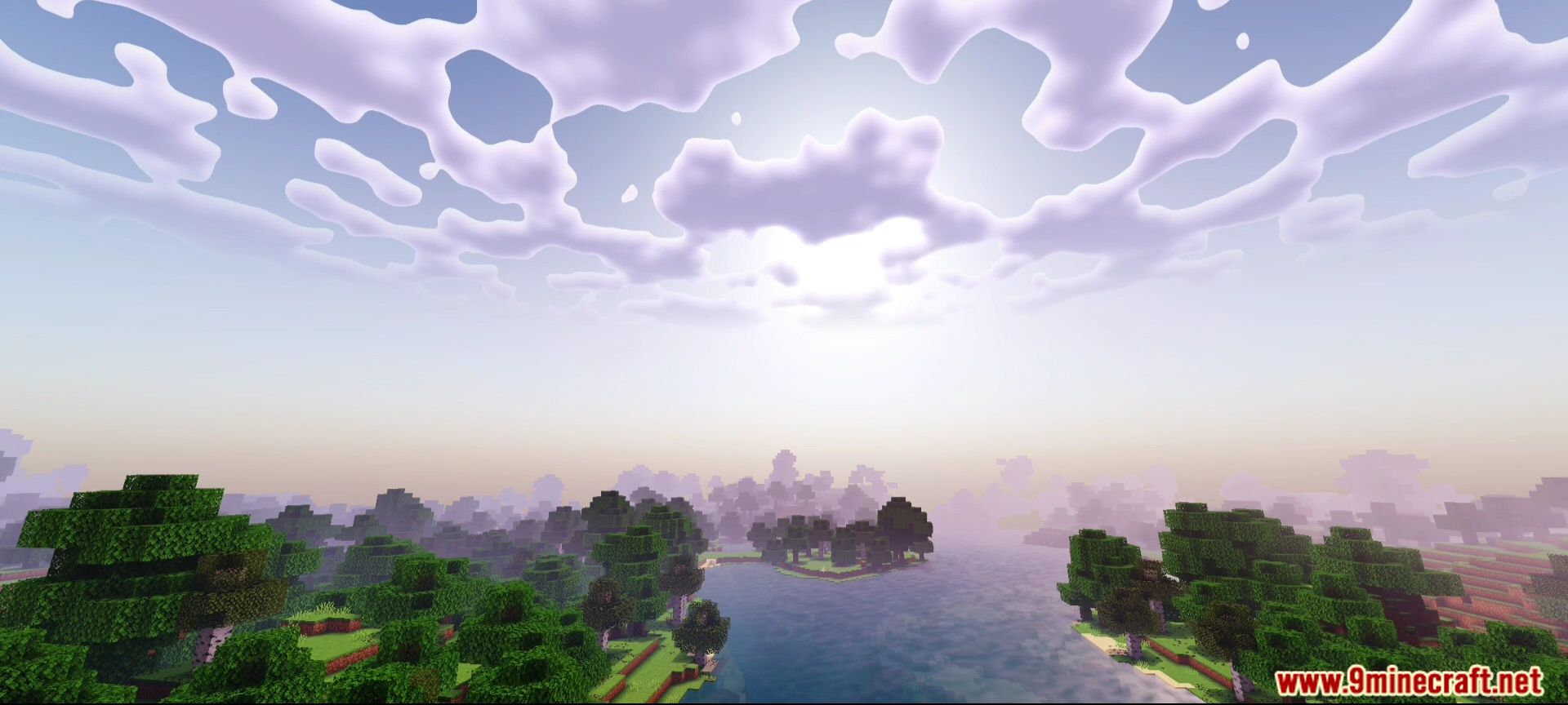 A scenic view of a river and forest under a cloudy sky