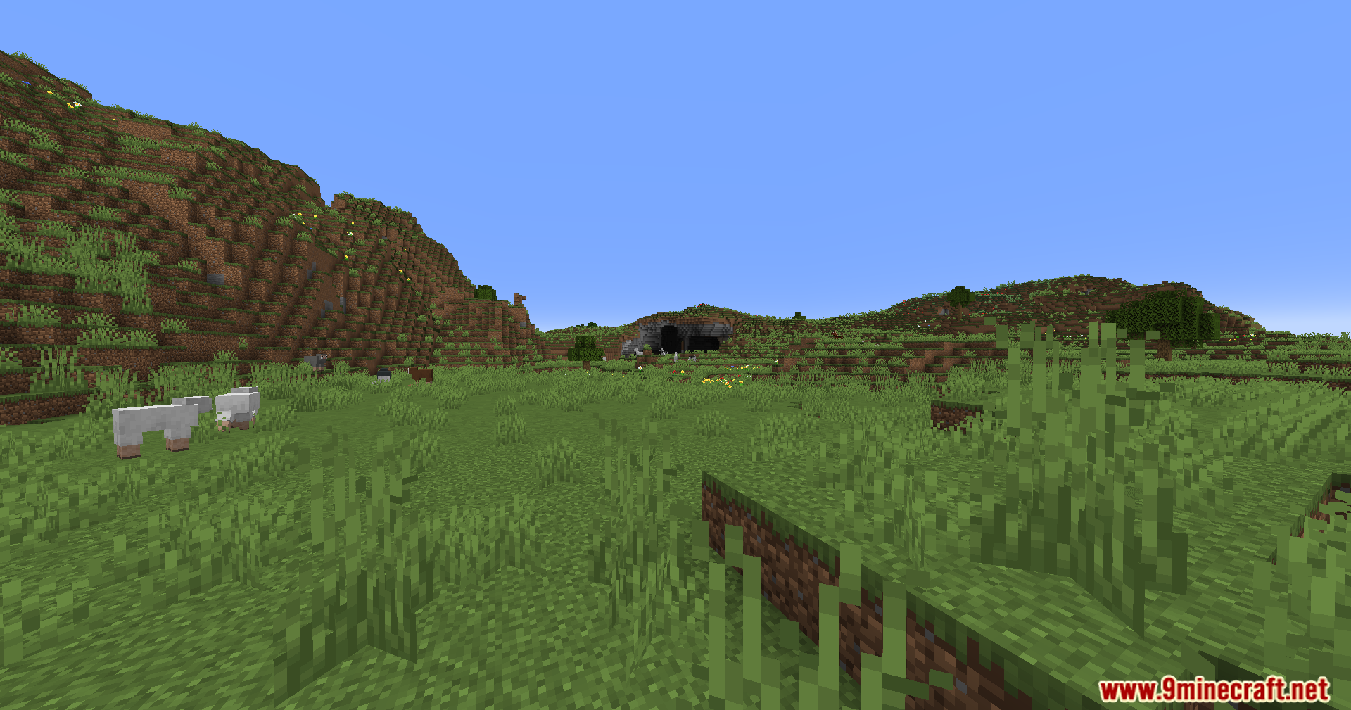 Noisiumed Mod Screenshot 10 Grassy terrain with rolling hills and a cave entrance in the distance