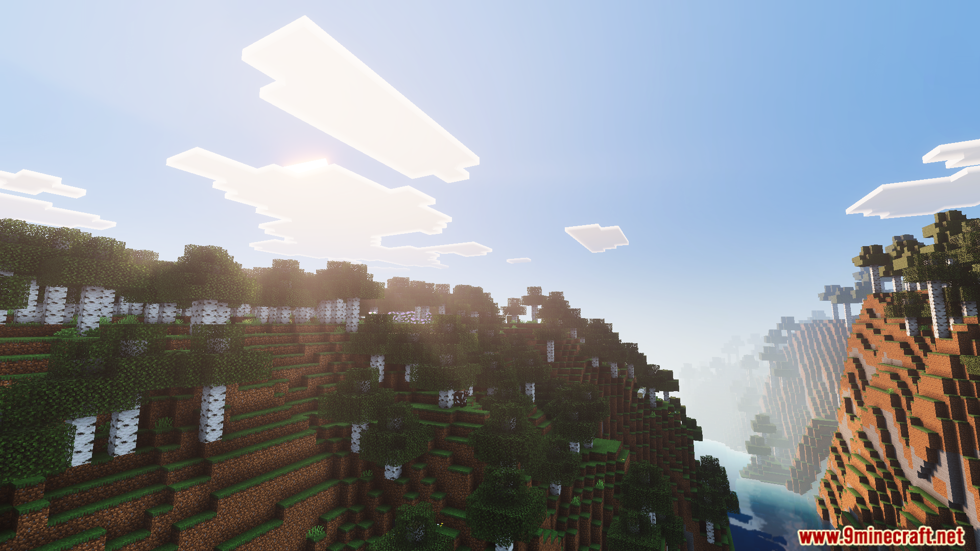 Bright skies and thick fog over a lush green landscape