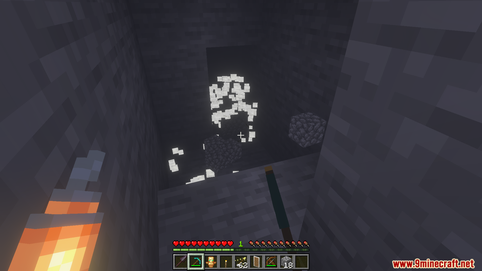 Player holding a torch in the left hand while mining a cave