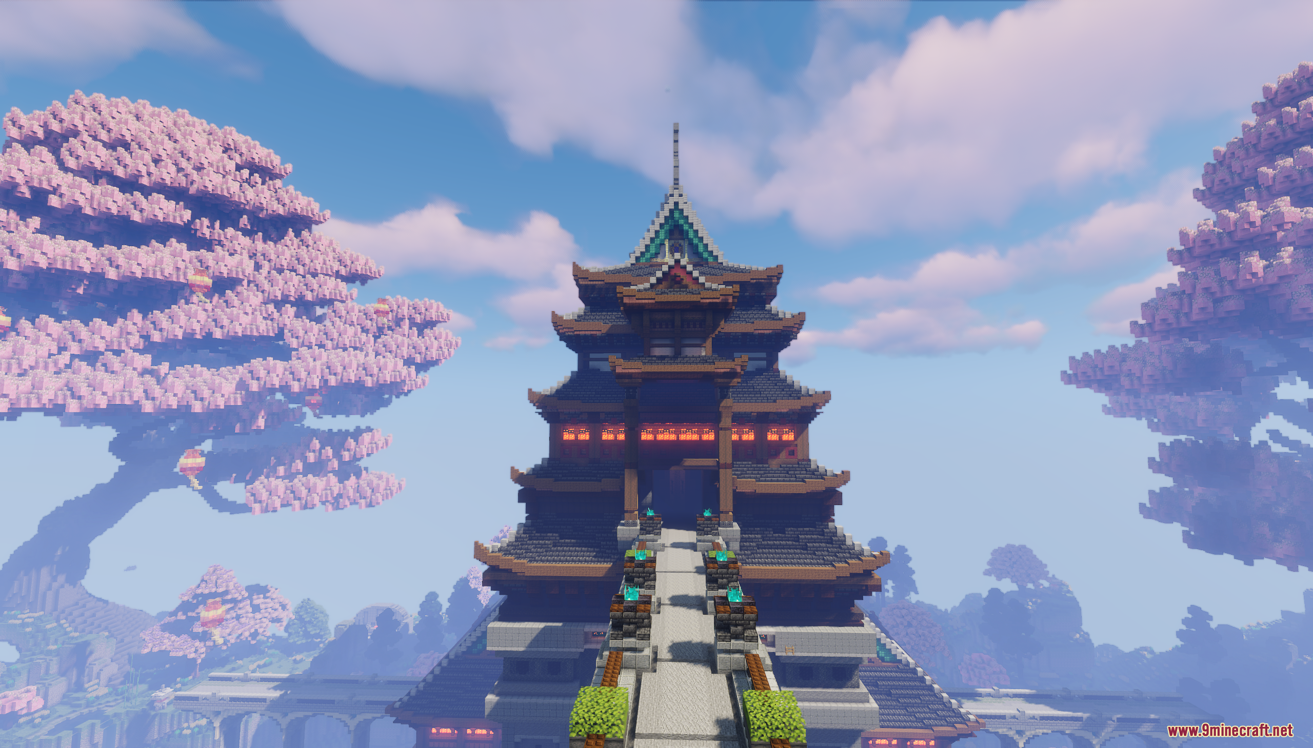 Large oriental building with a stone walkway flanked by pink cherry blossom trees