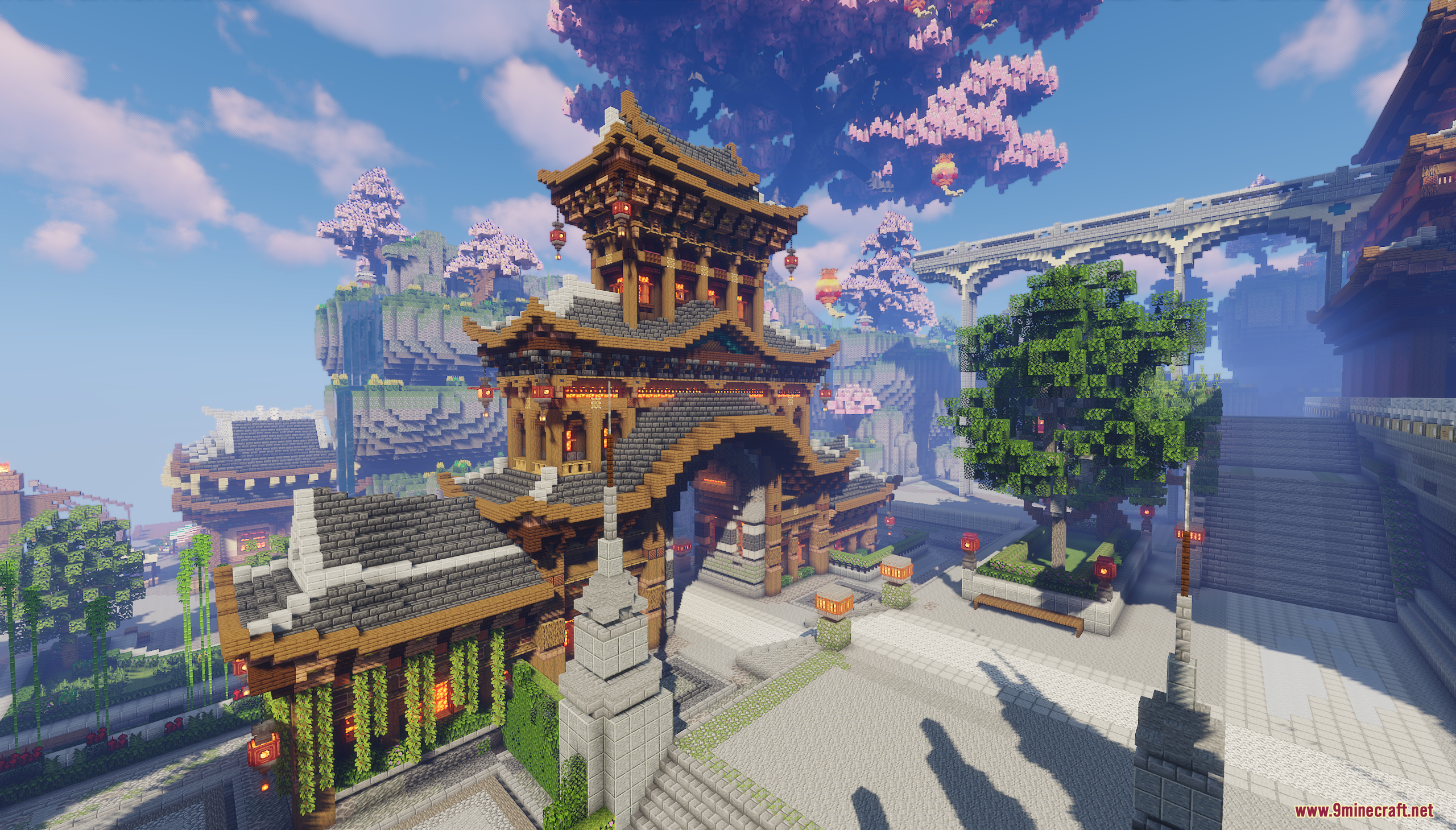 Large Asian style gate building with red lanterns and cherry blossom trees nearby