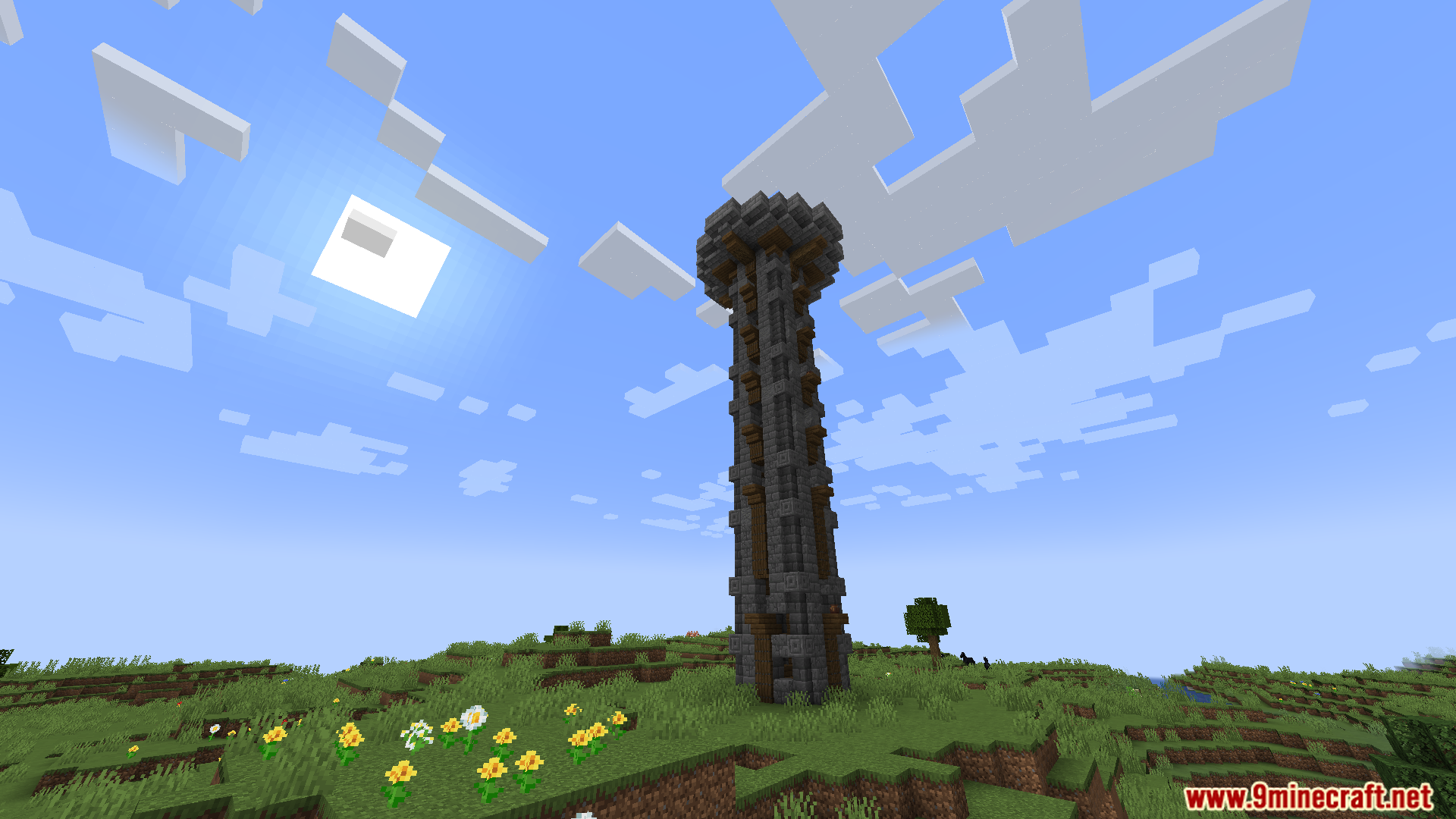 A tall stone watchtower stands in a grassy field