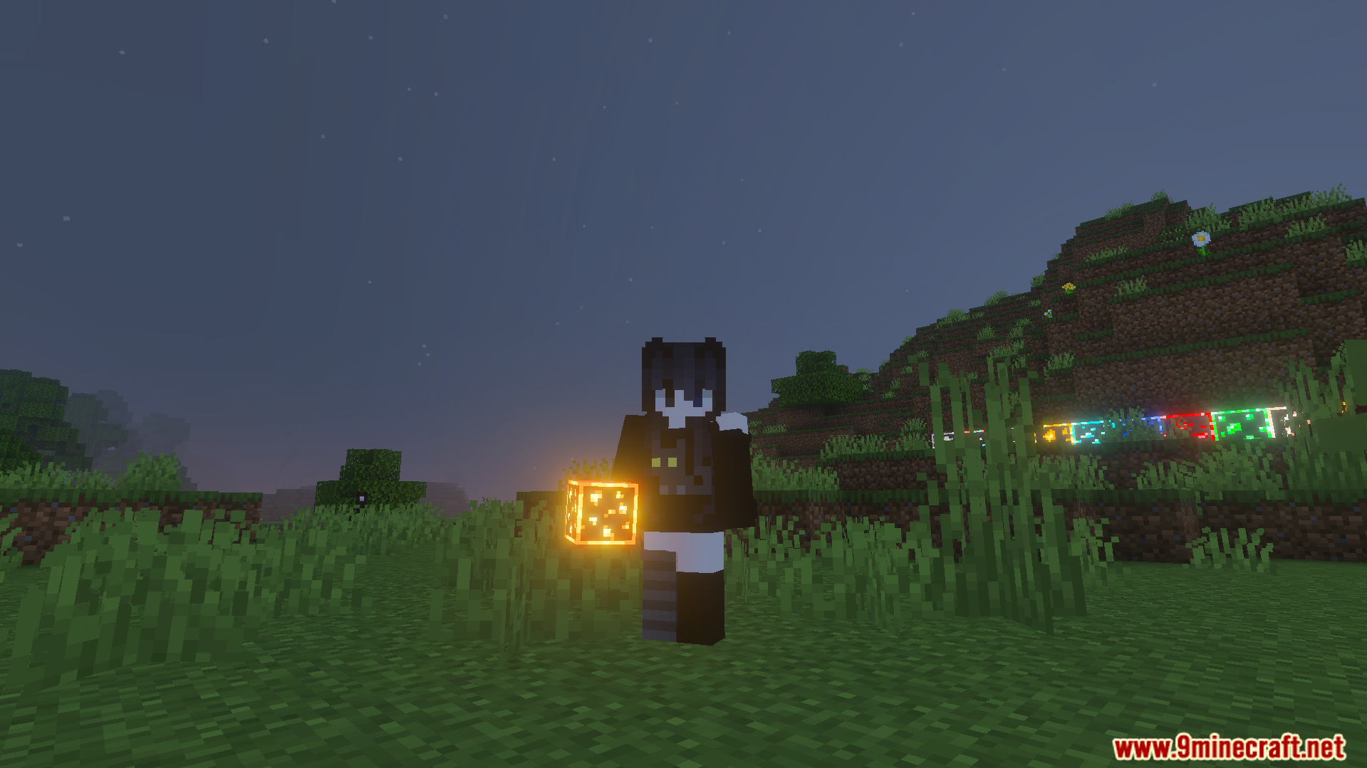 Player holding a bright glowing gold ore block during the night time