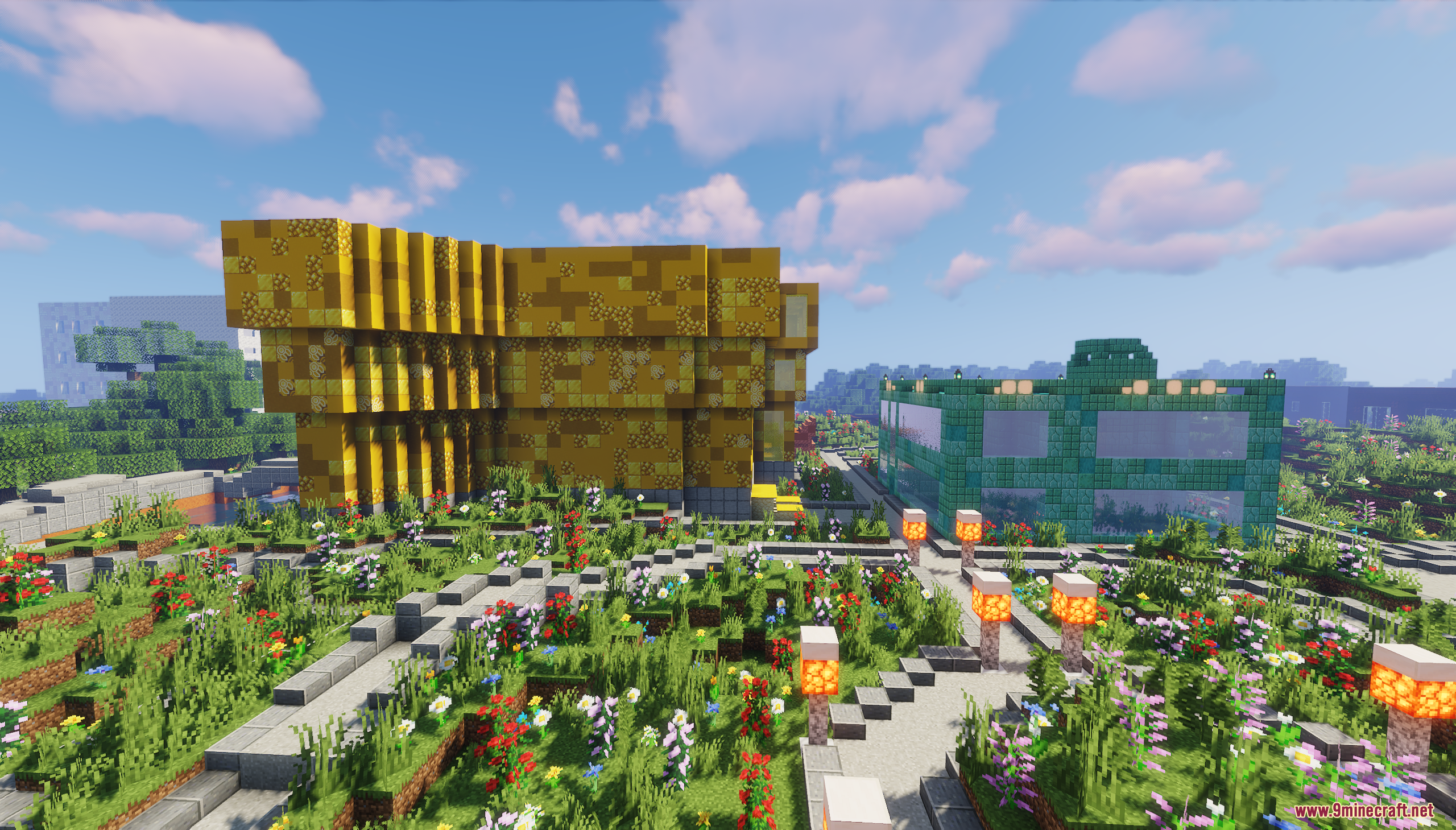 Yellow and green glass buildings stand beside a detailed garden with stone paths