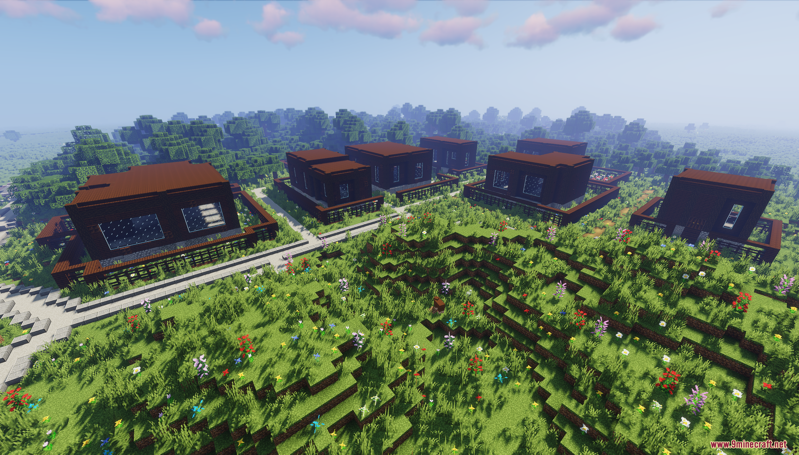 Identical dark brown modern houses arranged in a small neighborhood on grassy hills