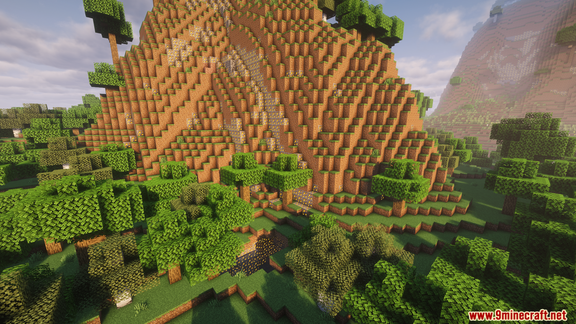 A large terraced mountain with a path in a forest
