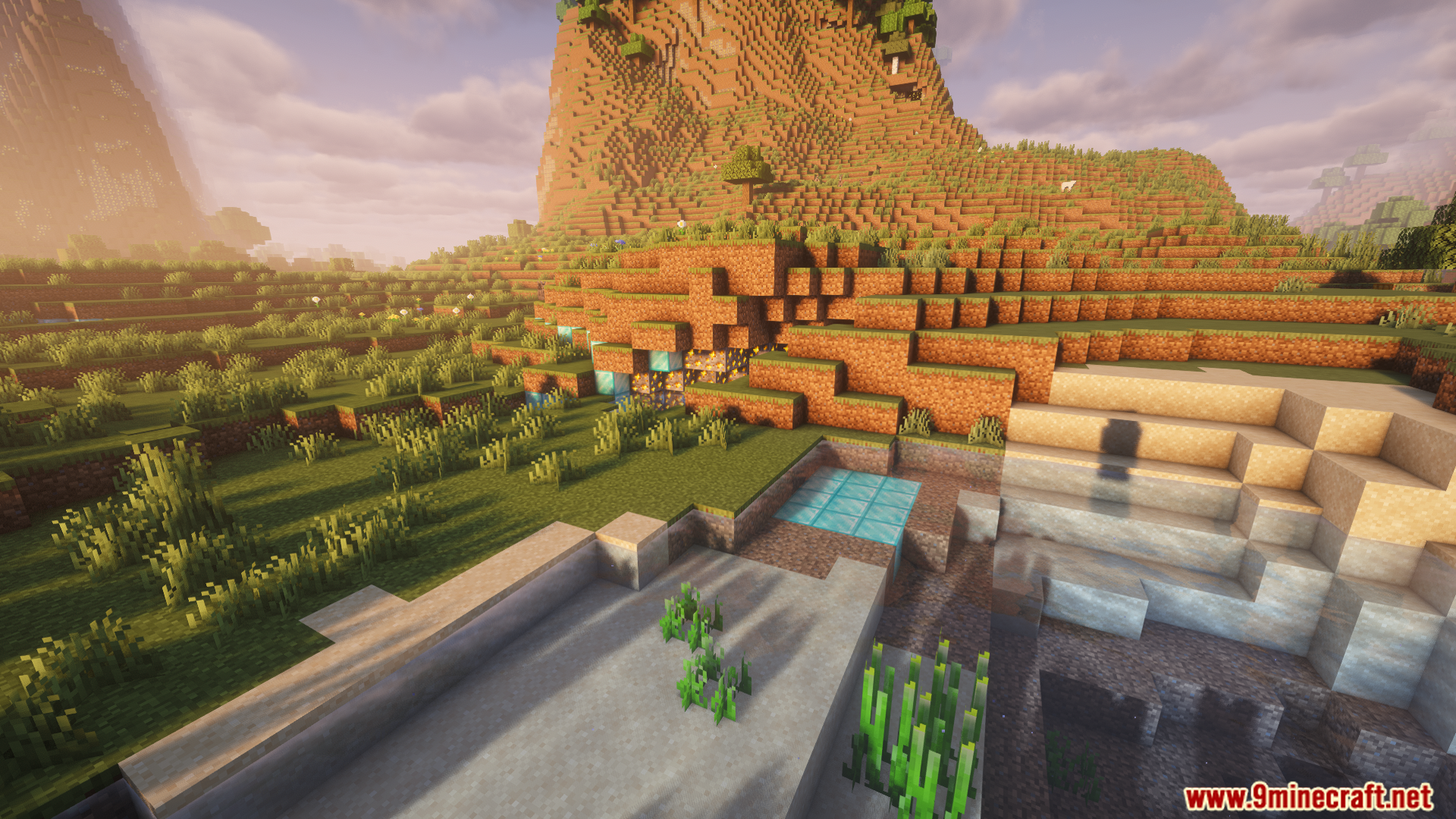 Sunlit Minecraft landscape with terraced hills and a river