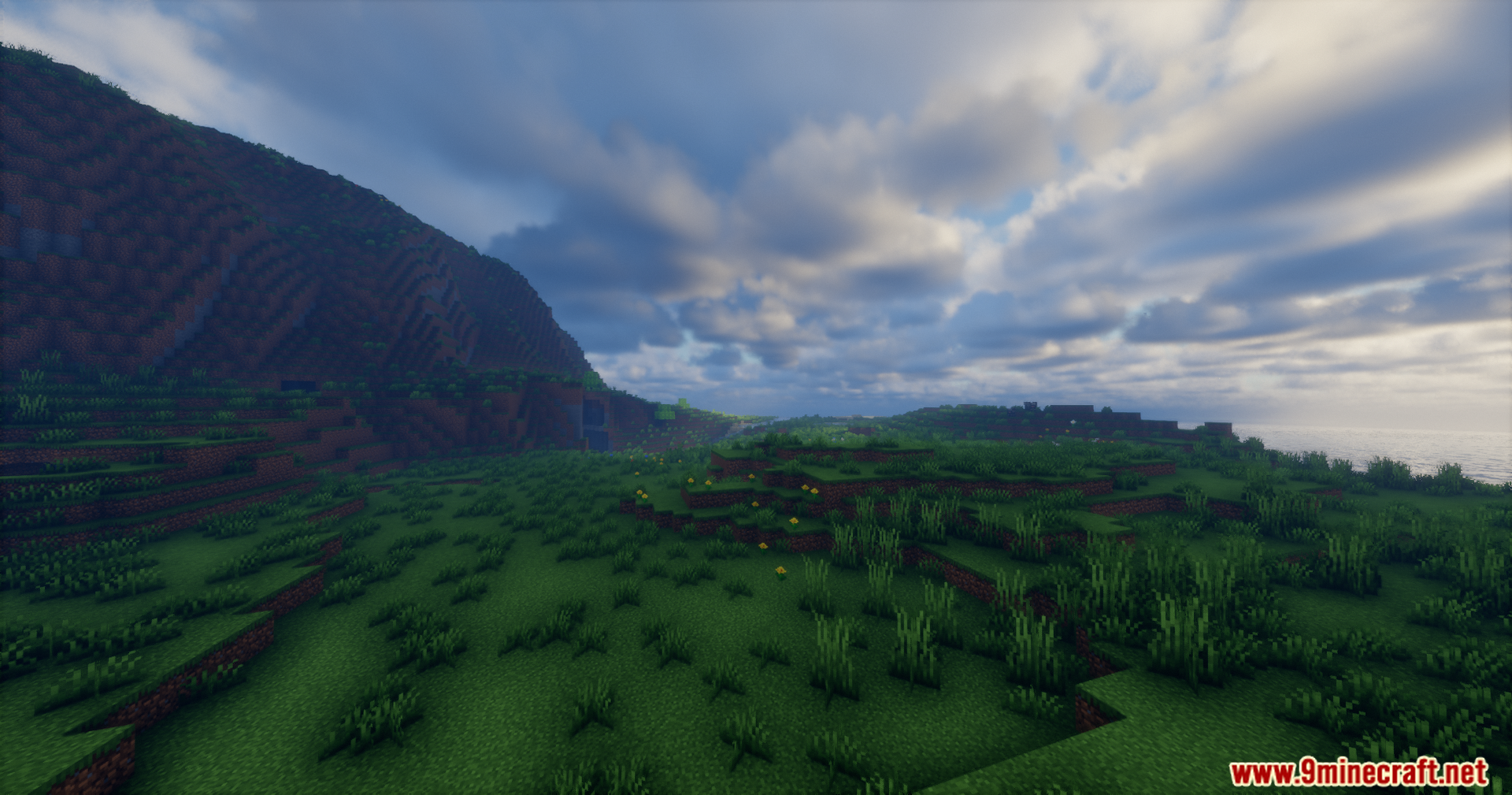 Rrtt217 S Hdr Mod Screenshot 13 Wide Minecraft landscape featuring green hills and a realistic cloudy sky with enhanced lighting