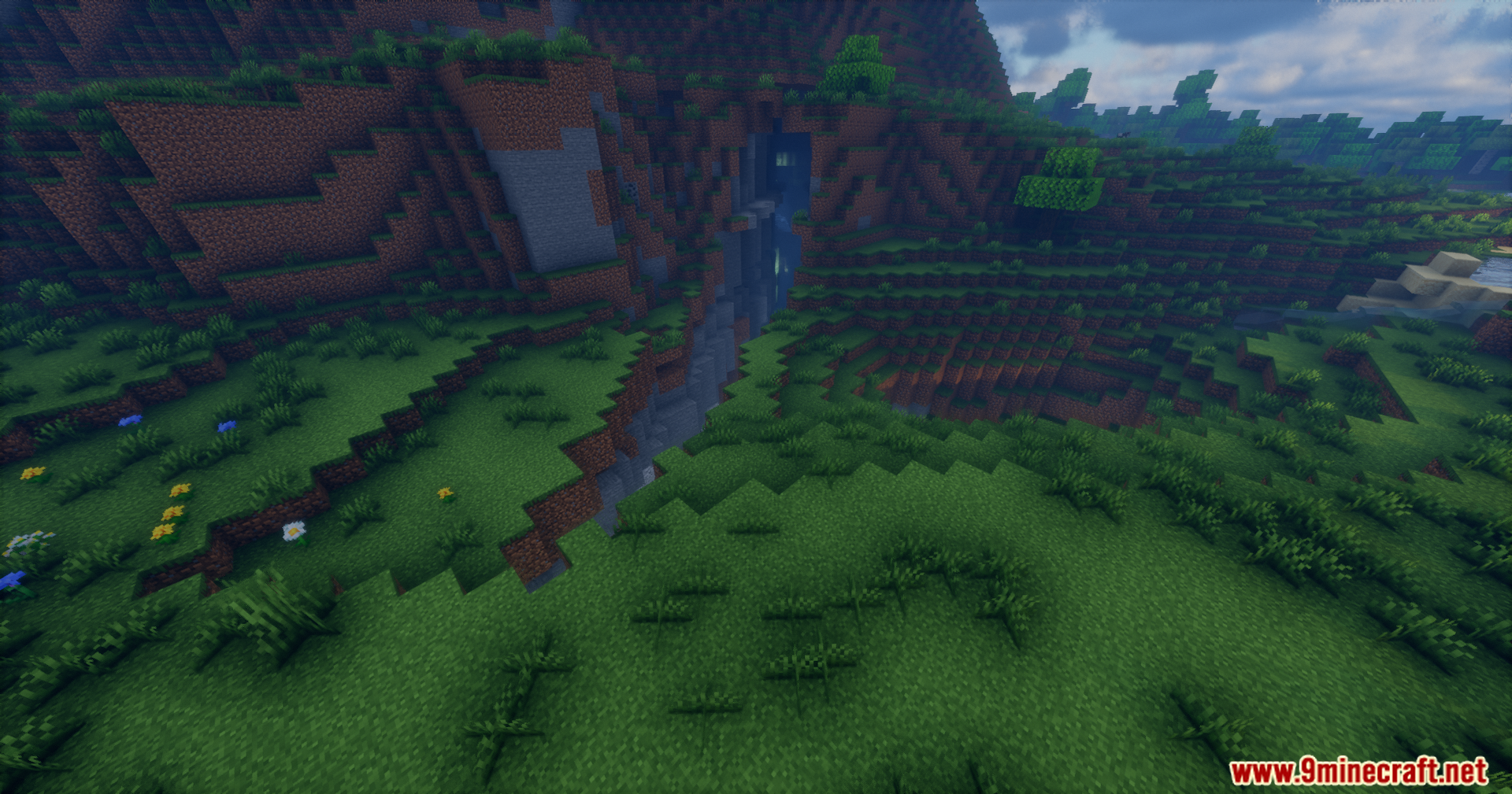 Rrtt217 S Hdr Mod Screenshot 14 Grassy terrain in Minecraft showing a small ravine with water and enhanced shadows