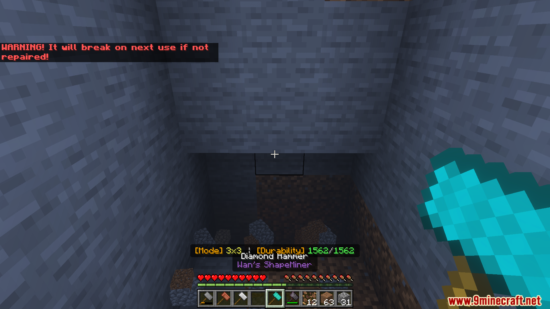 Player holding a diamond hammer in a stone tunnel