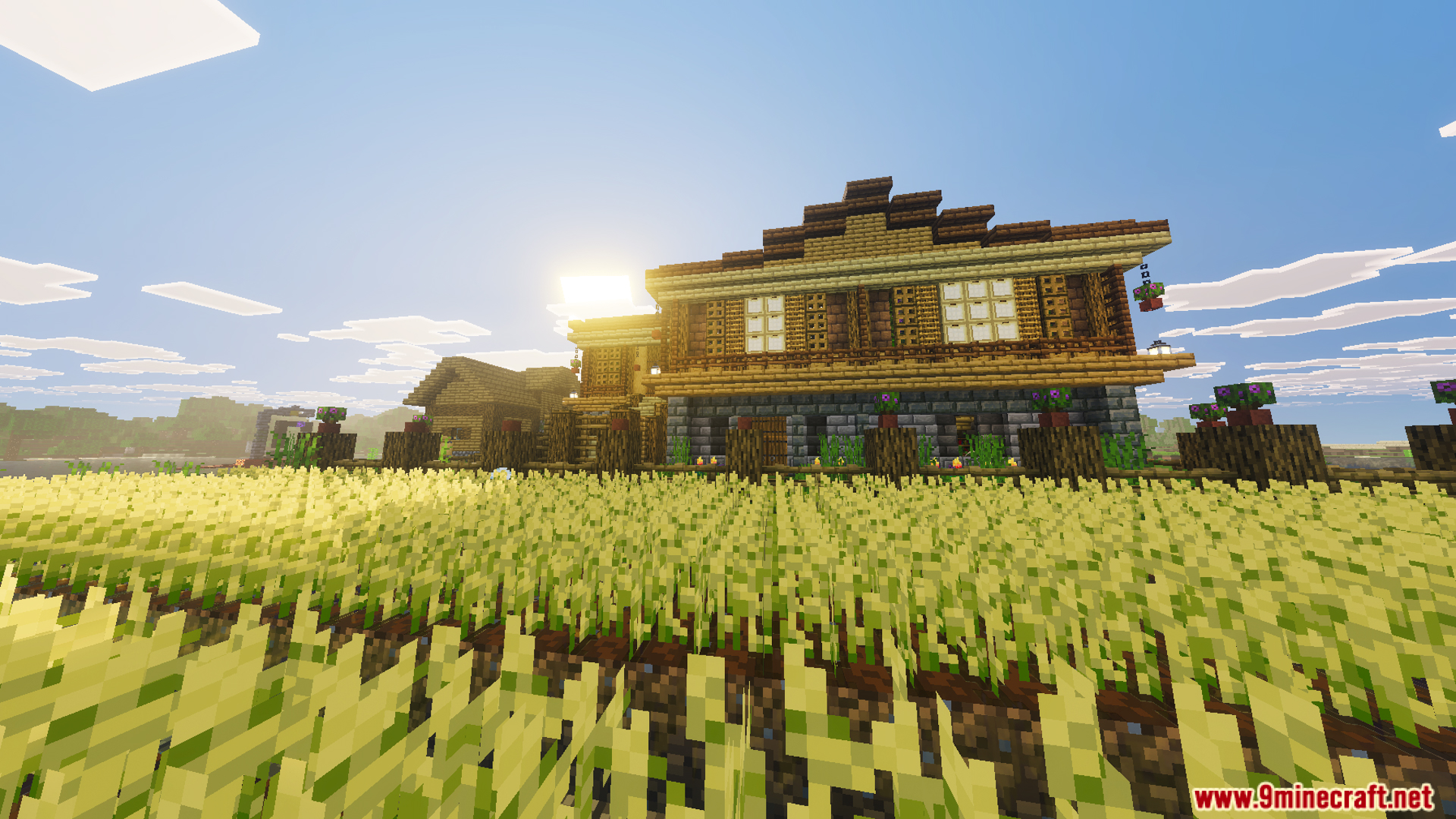 Exterior view of a large two story wooden house with a wheat farm
