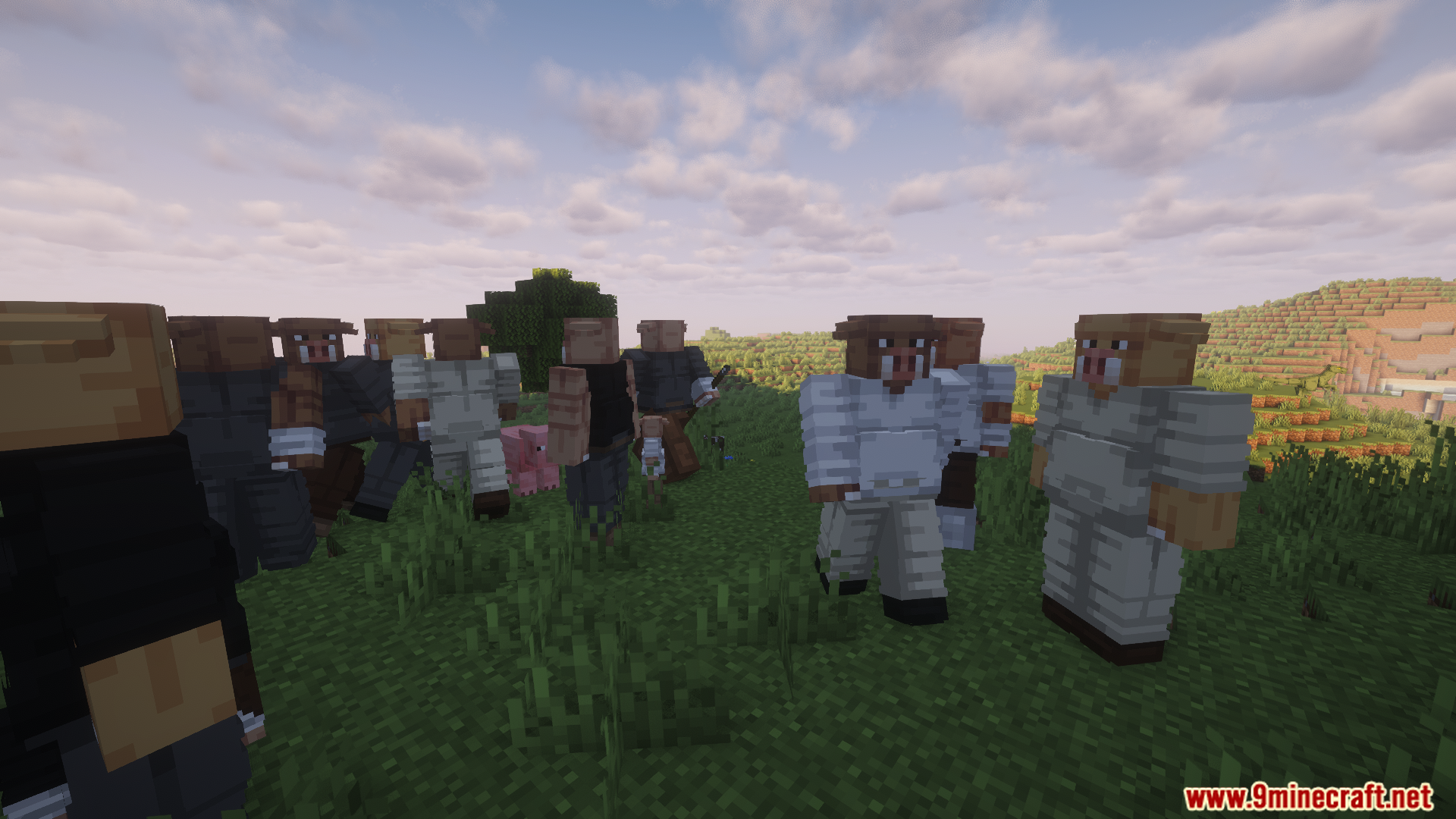 A large group of villagers gathers in a grassy field