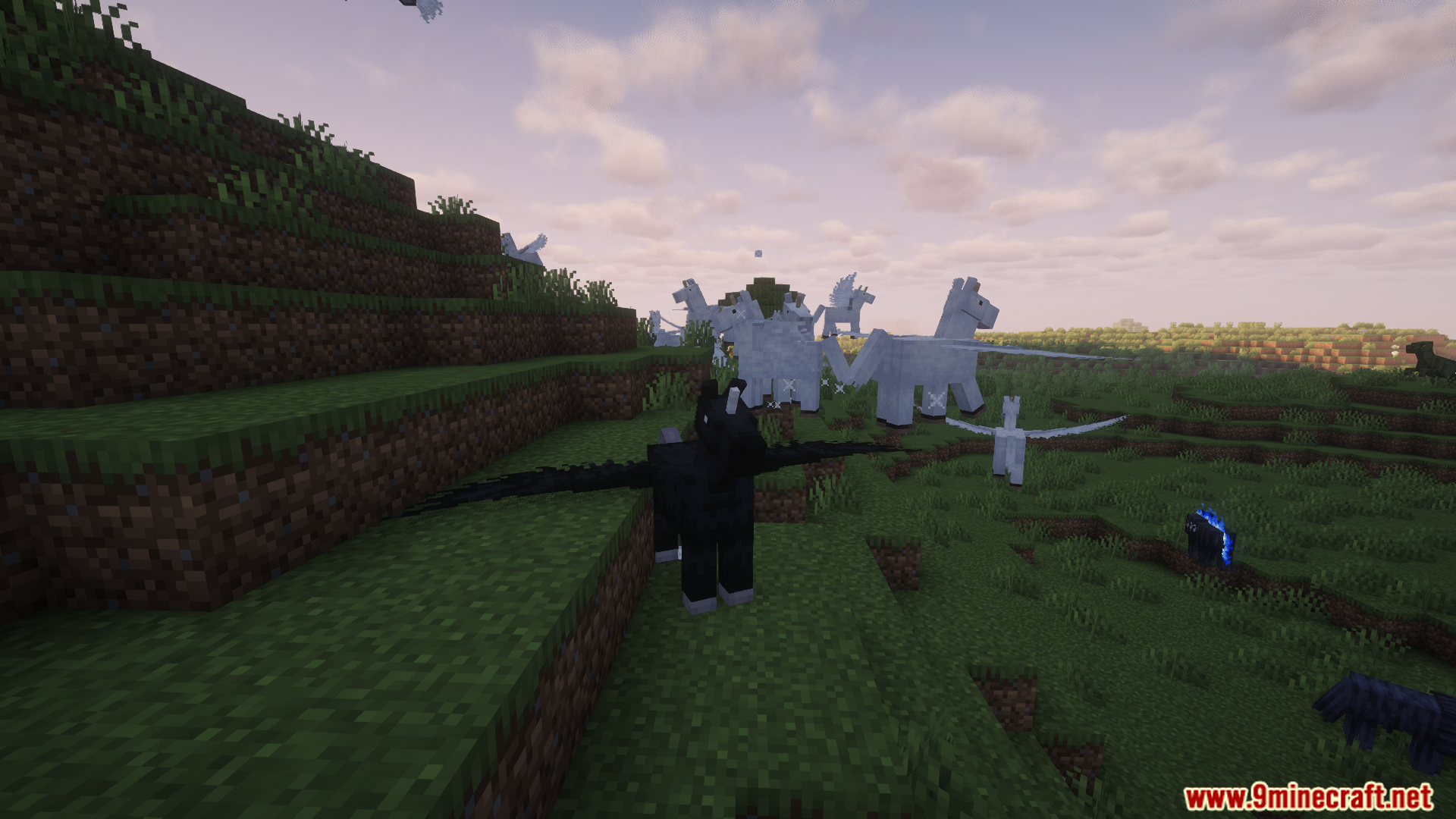 A black winged creature and other monsters on a hillside