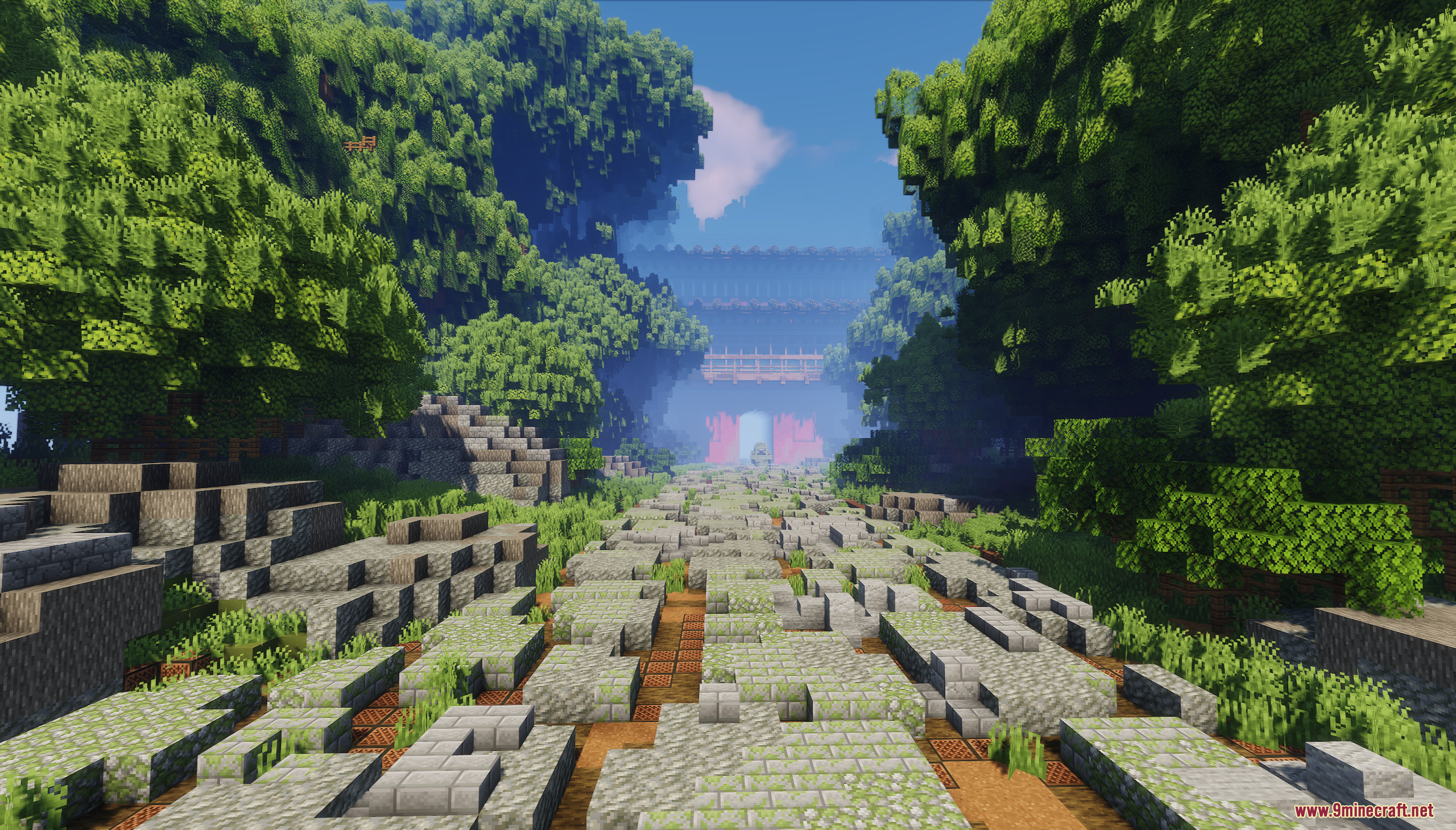 Wide stone path leading through a forest to a distant gate
