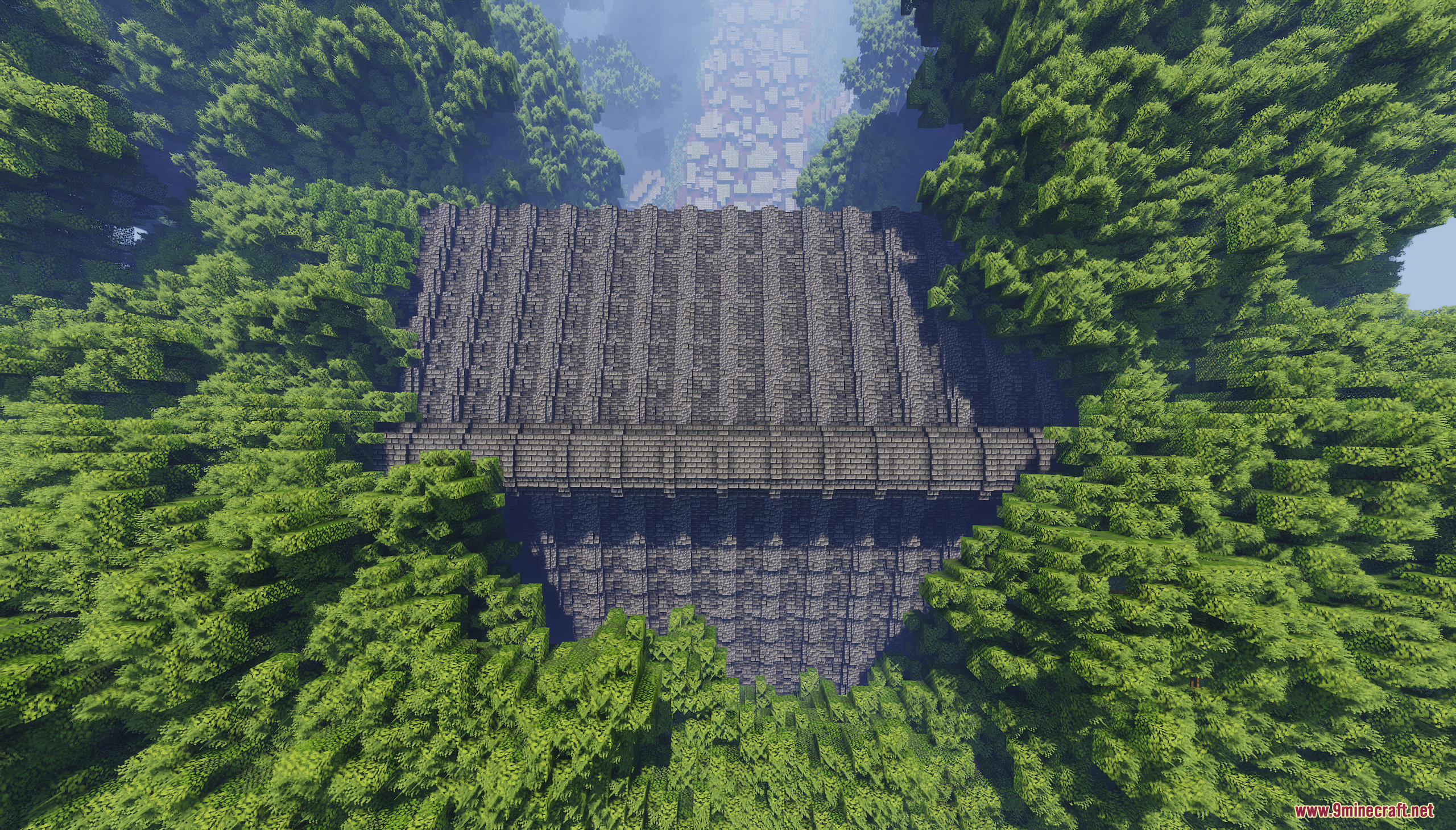 Aerial view of a large stone structure surrounded by dense forest