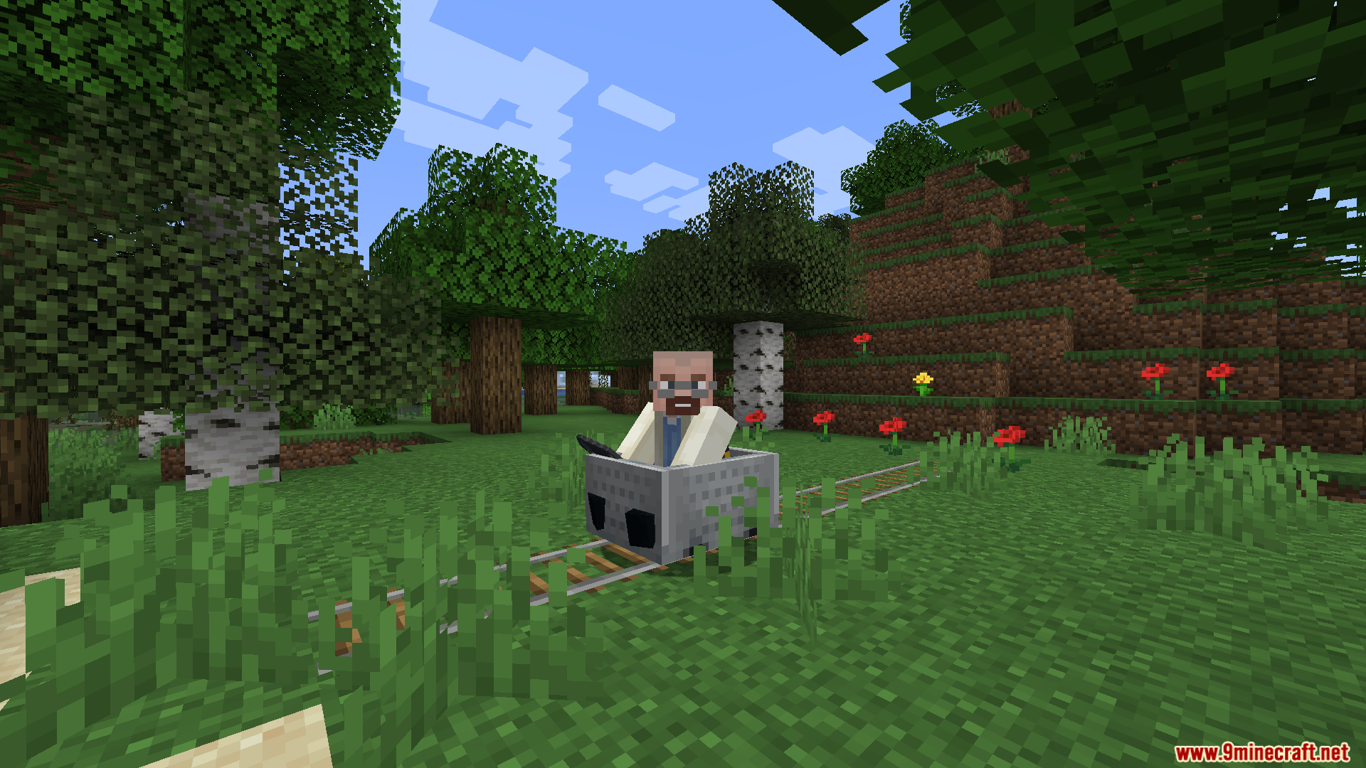 A bald man with a beard riding in a minecart