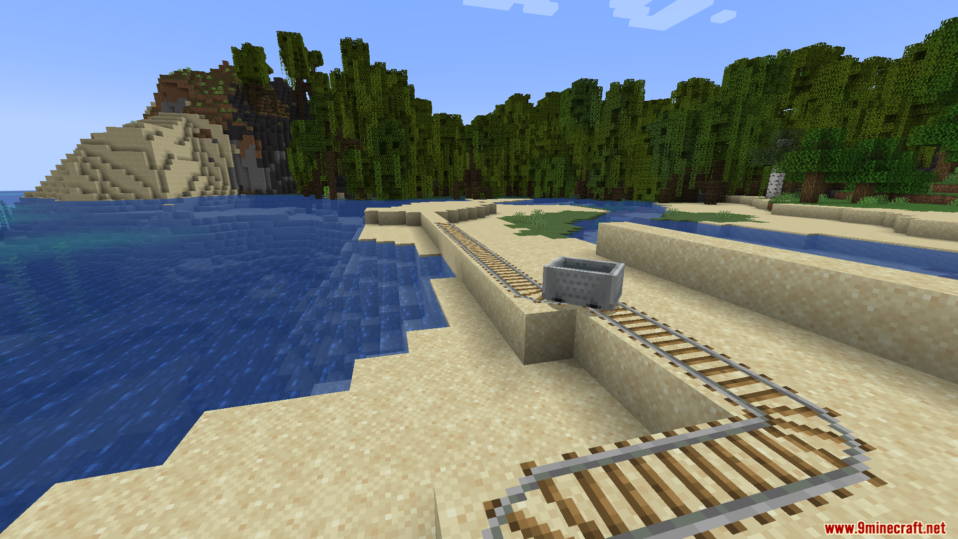 A single minecart sits on a track by the water