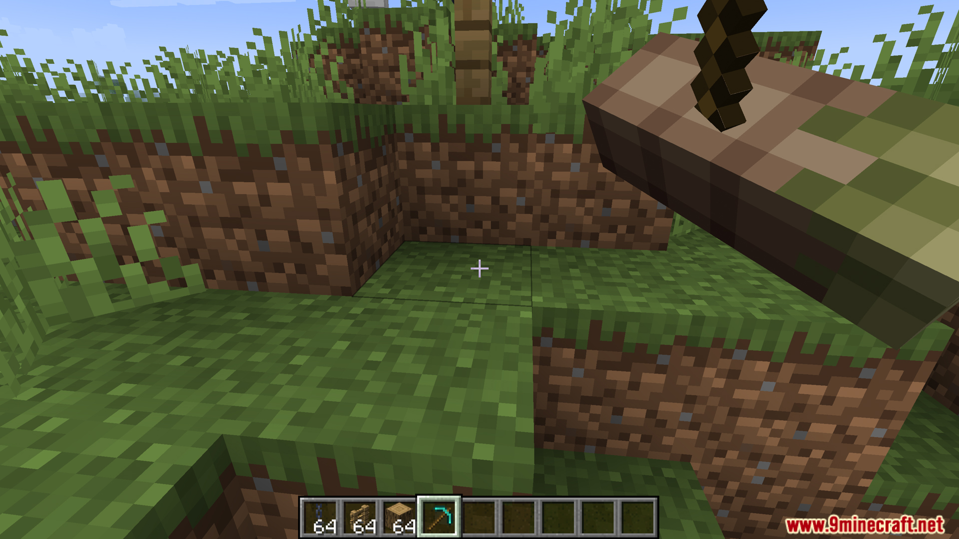 Player looking at a grassy area holding a pickaxe