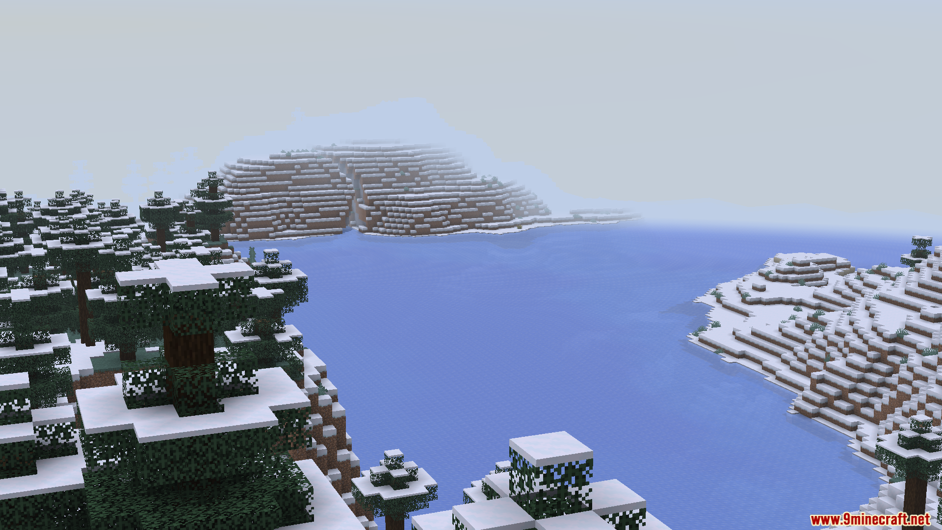 Zoomed in view of a snowy mountain across the water