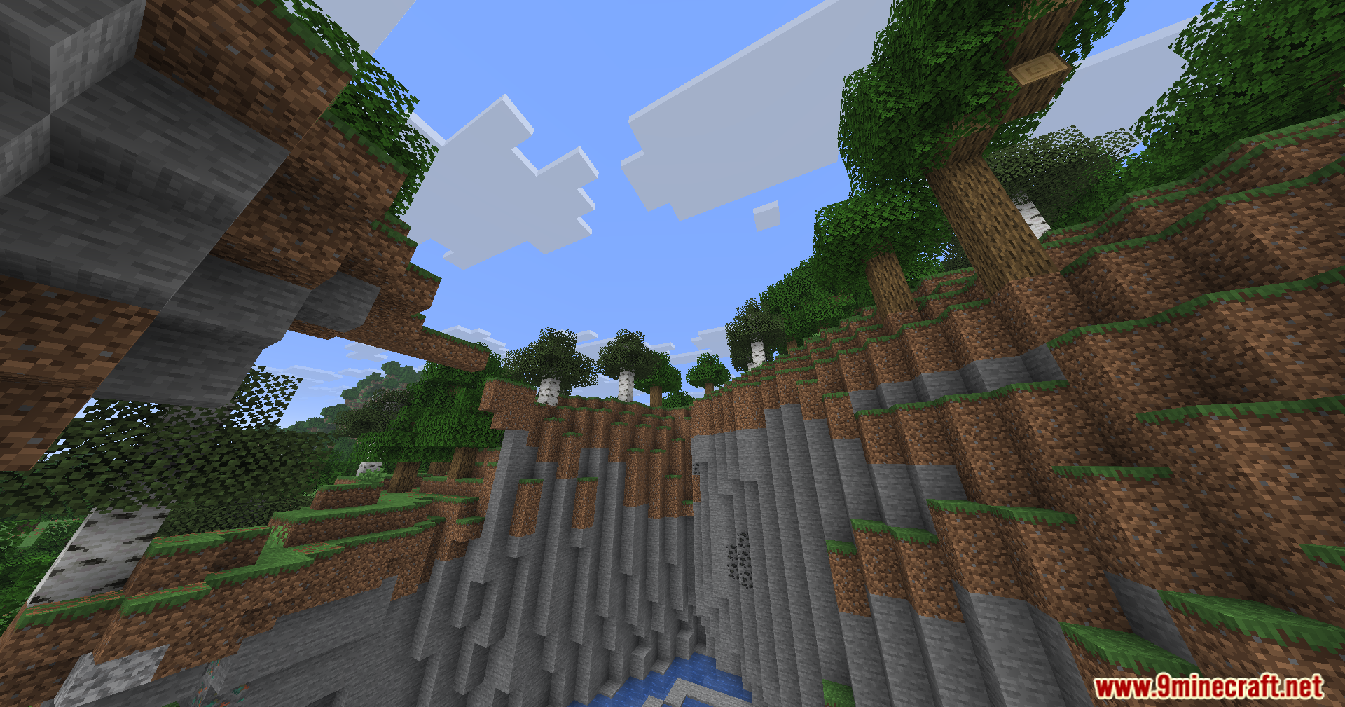 A steep cliffside with stone and dirt blocks under a clear blue sky