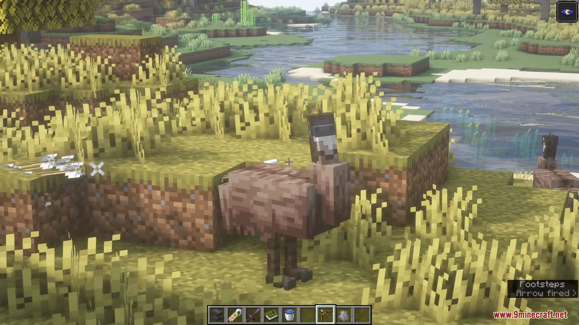 An emu stands in a grassy field near a river in Minecraft