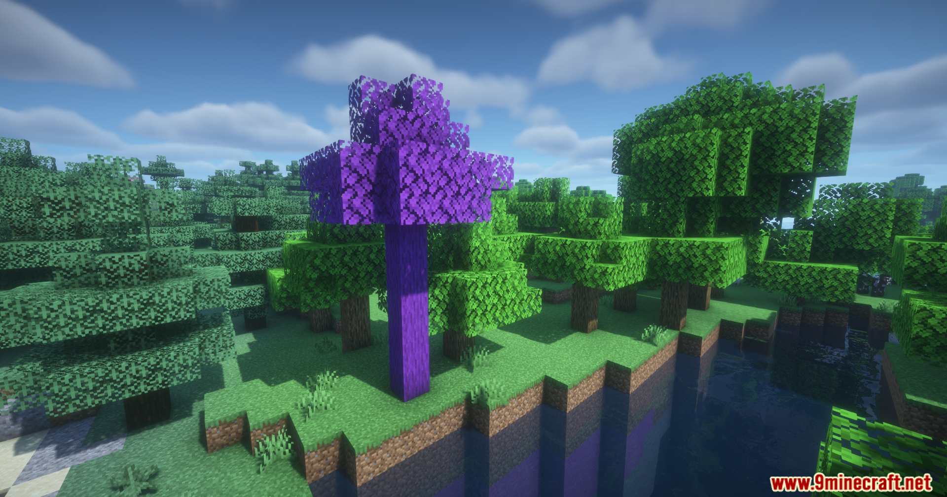 A vibrant purple tree stands near a river in a green forest