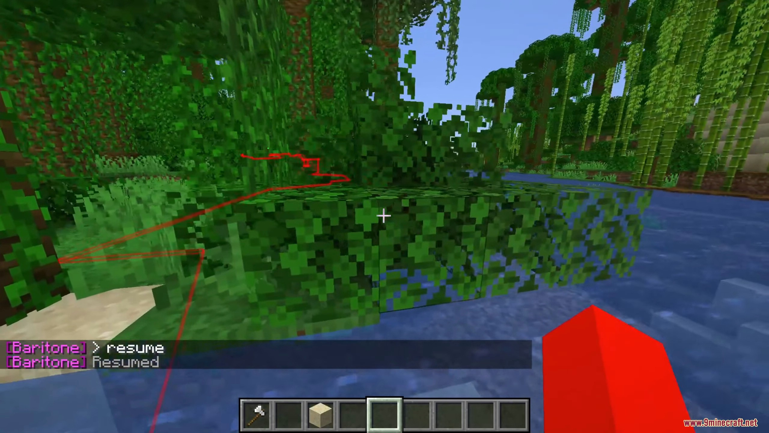 A red pathfinding line guides the player across leaves near a river.