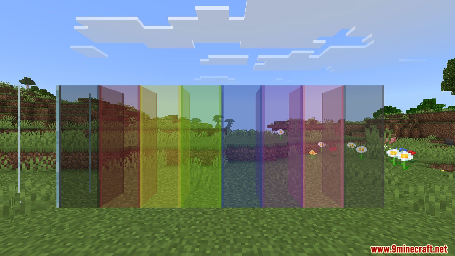 Multiple colored glass blocks without edge lines standing in a grassy field