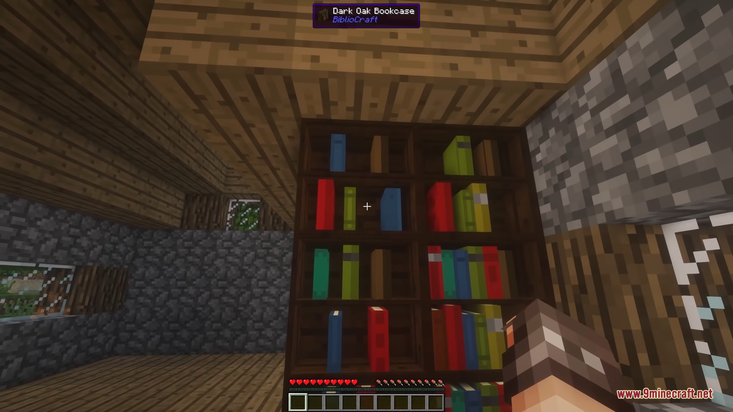 Dark oak bookcase from BiblioCraft filled with various colorful books in a room