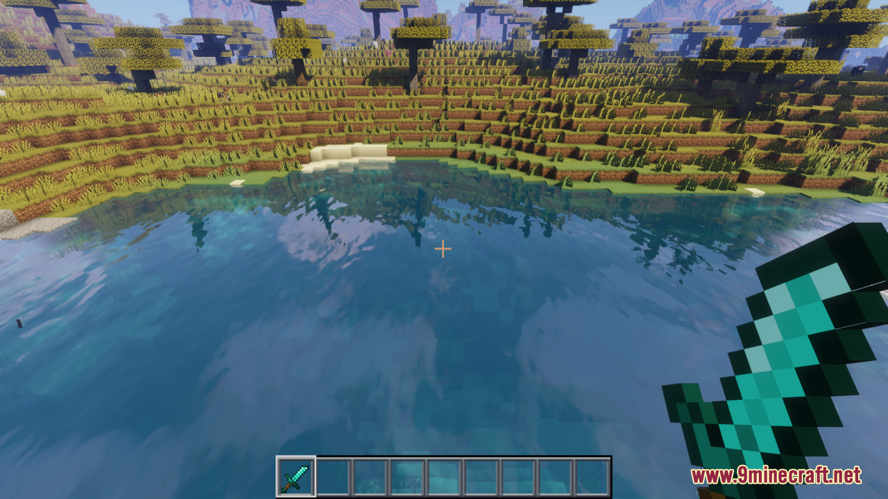 A player holds a short diamond sword while looking at a clear lake