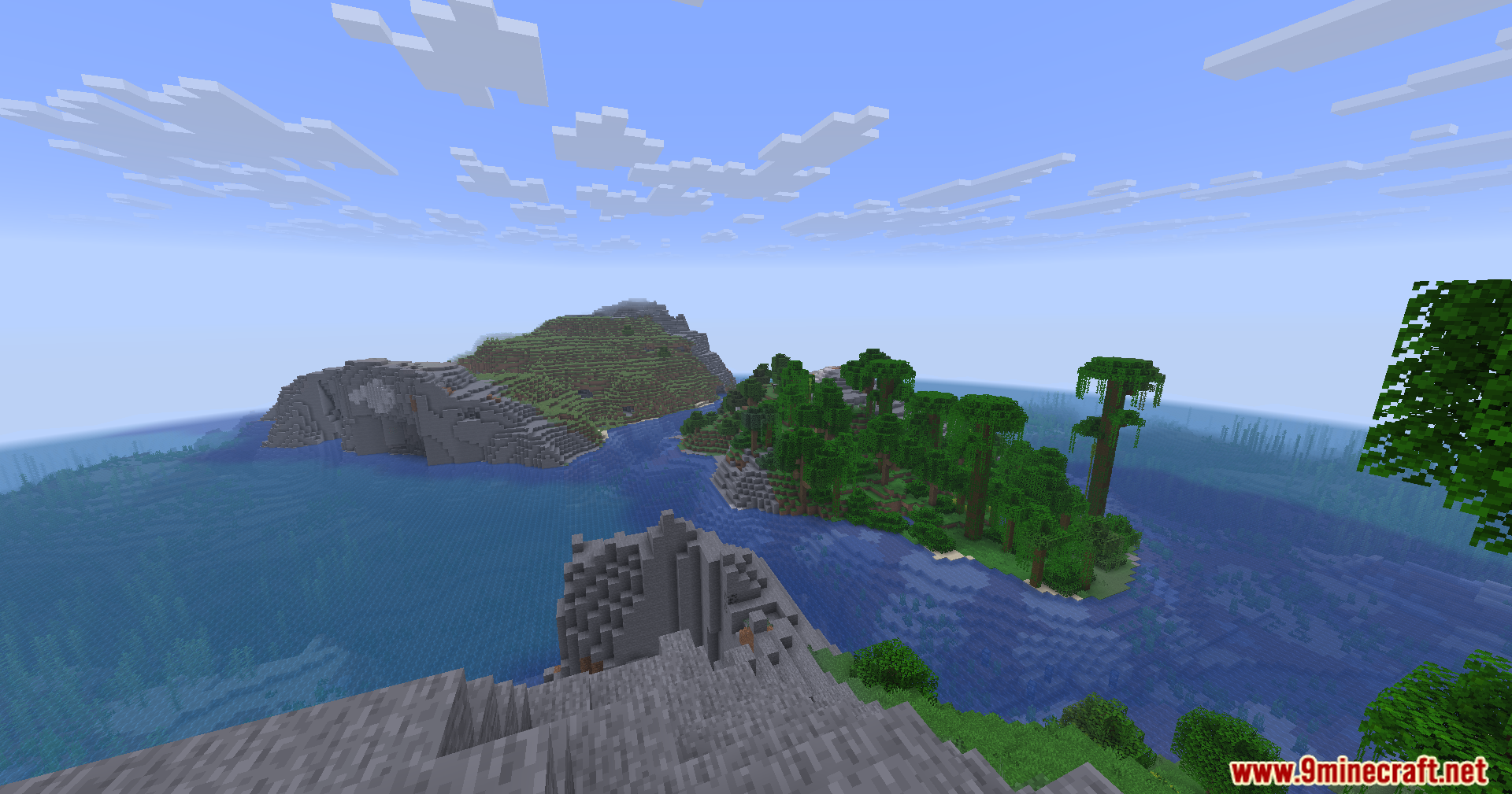 A wide landscape view of jungle biomes and rocky cliffs near the ocean