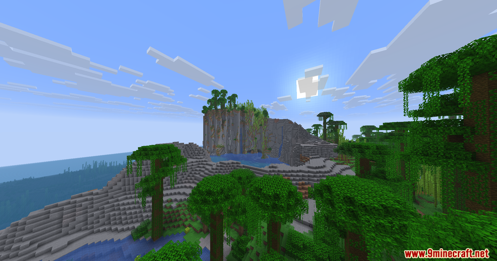 Sunlight shines over a dense jungle biome with steep cliffs and tall trees