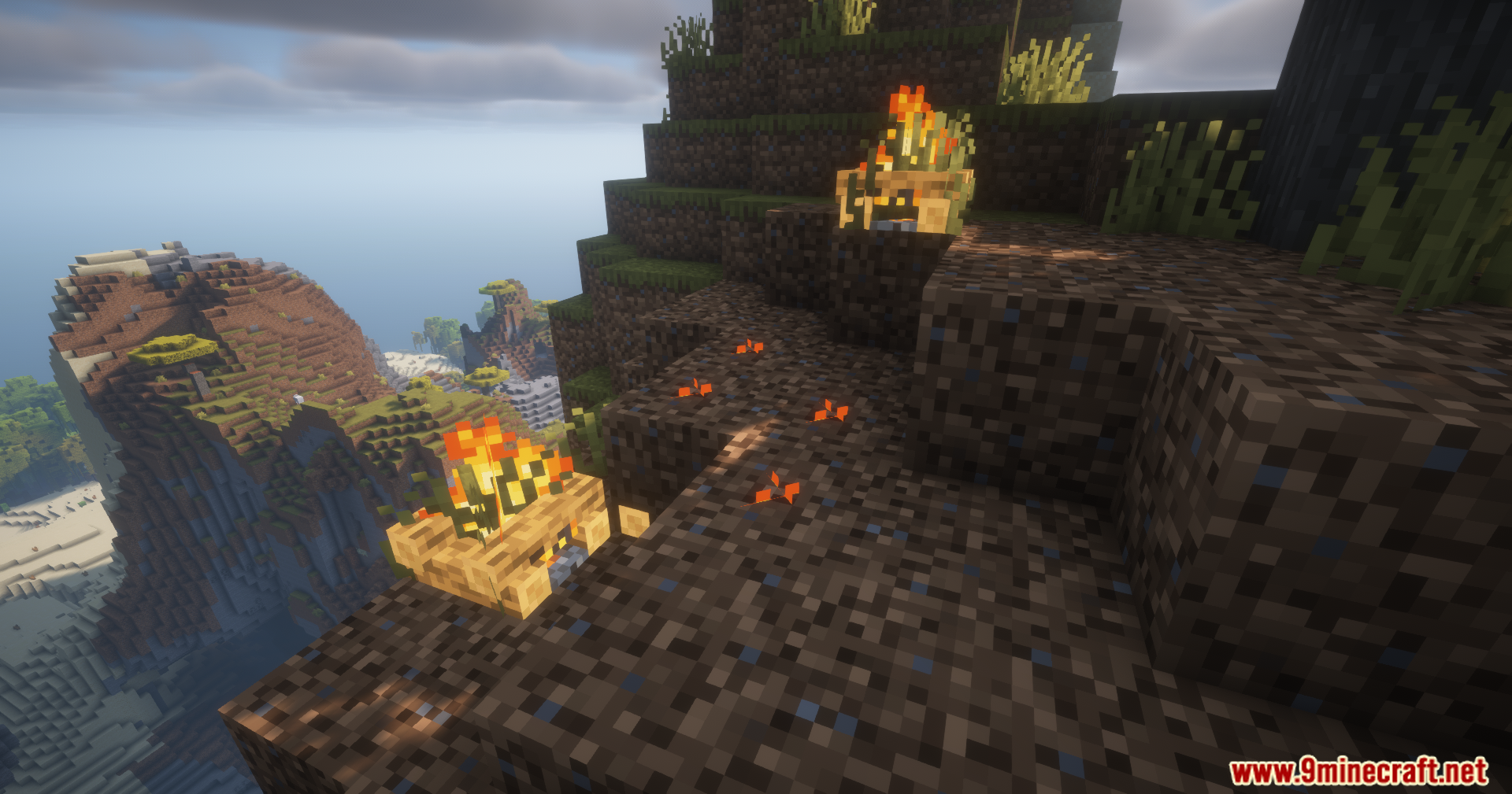 Orange particles floating over dirt blocks next to campfires on a cliff